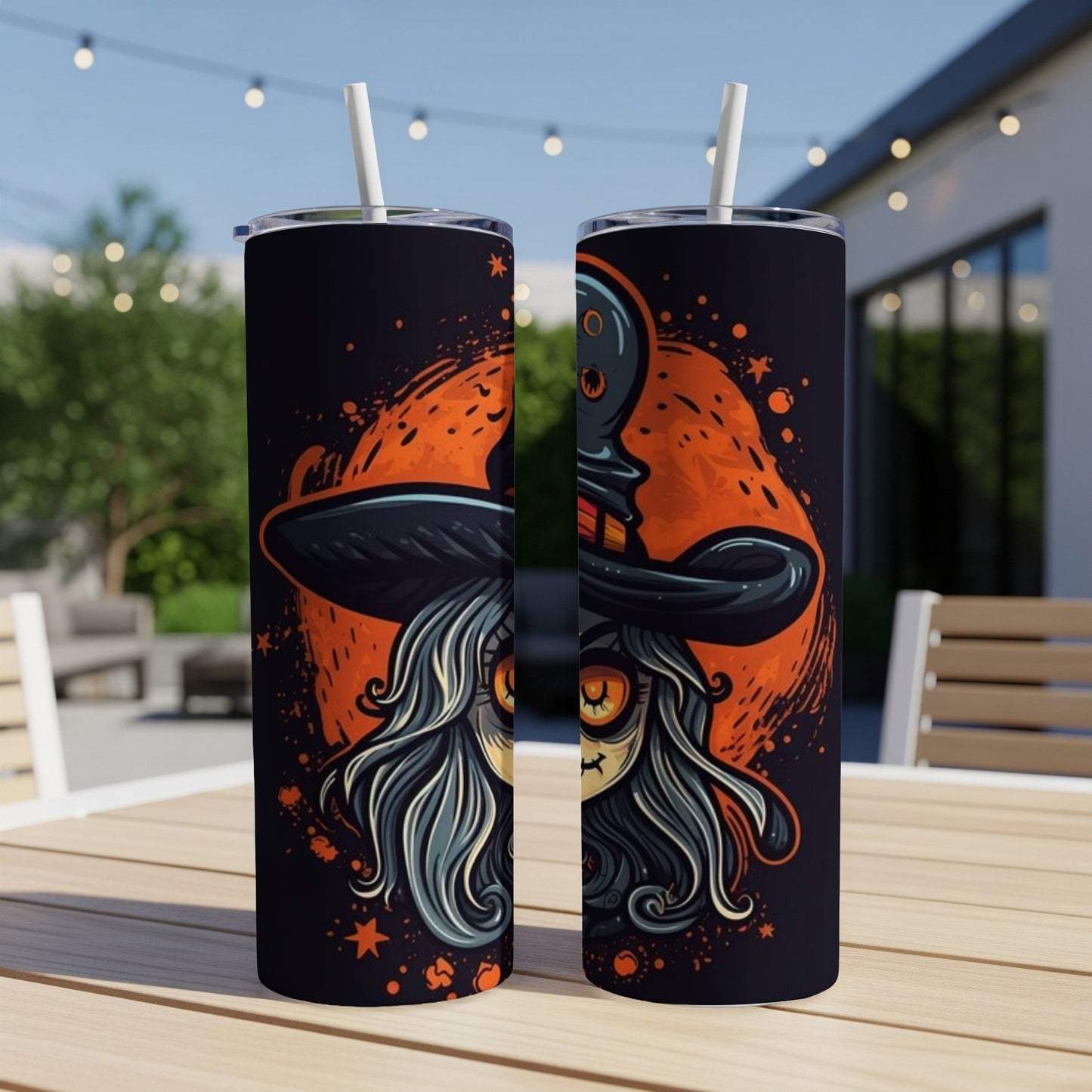 Two tumblers with Halloween witch artwork on a table outdoors.