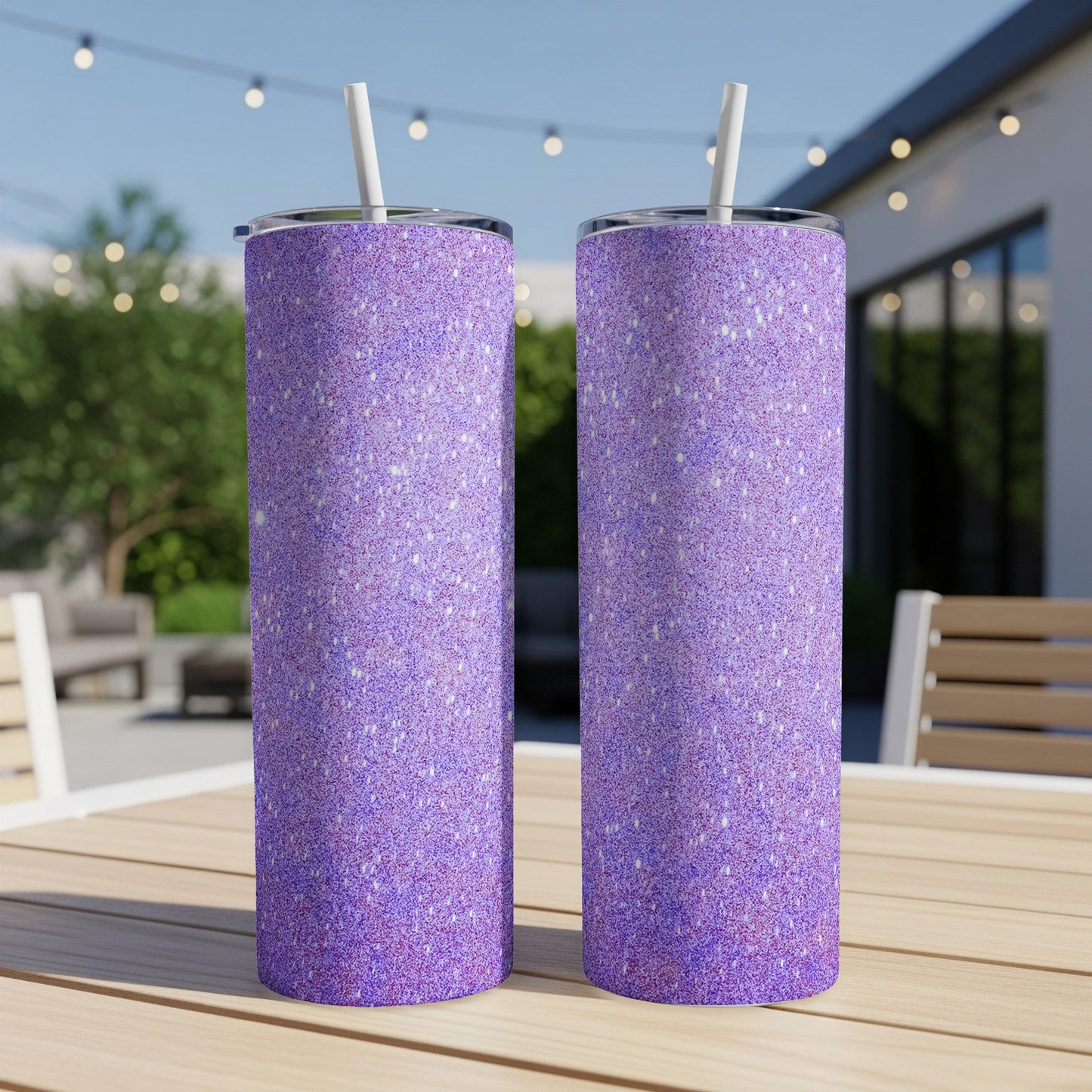 Two tall purple glitter tumblers with straws on a wooden table.