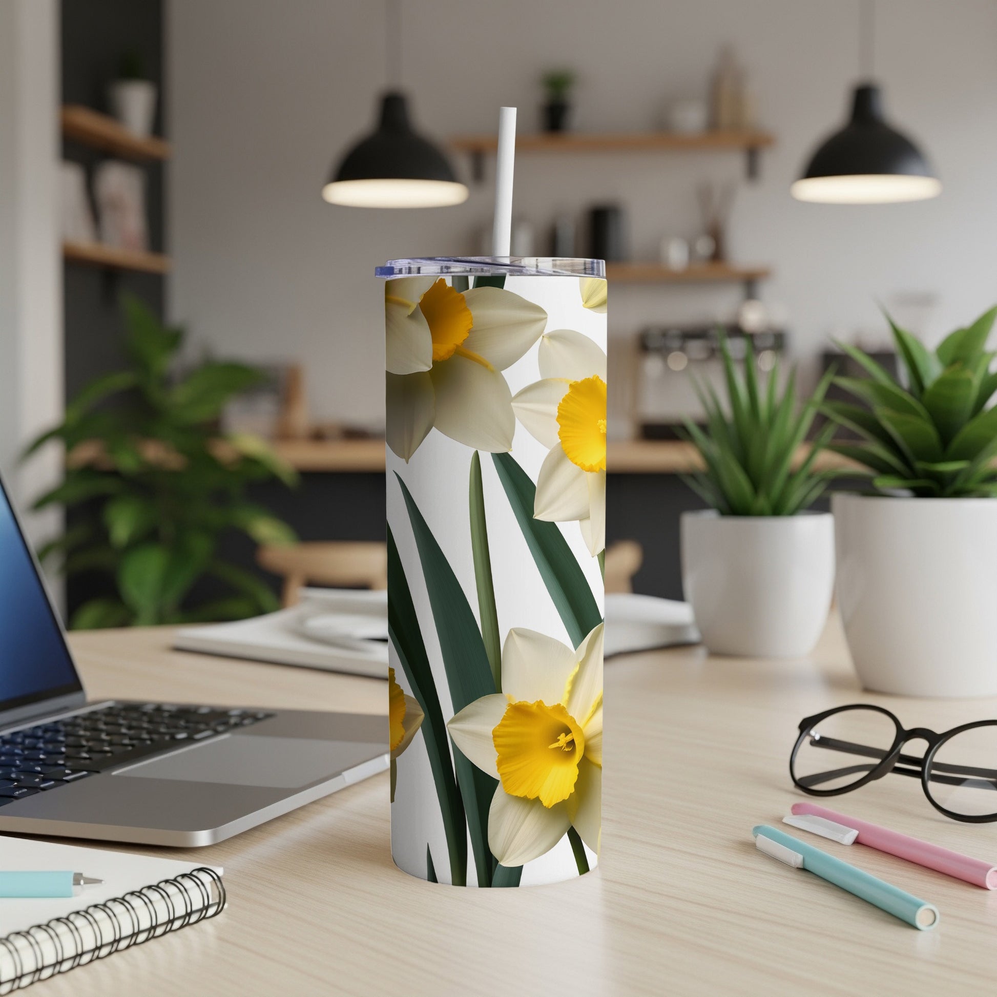 White tumbler with yellow and white daffodils and green leaves.