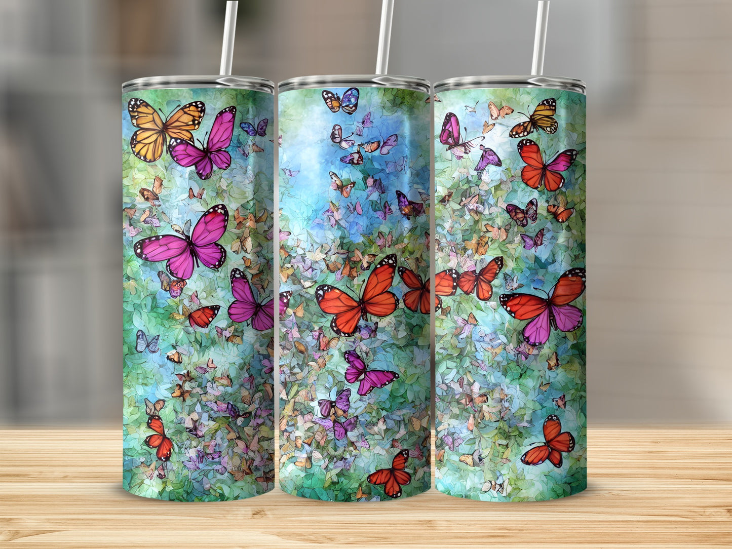 Three tumblers with colorful butterflies and floral patterns.