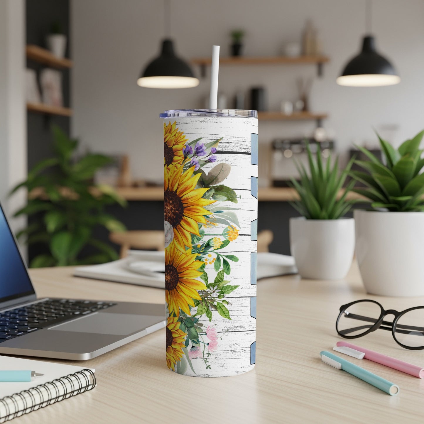 Tall tumbler with sunflowers and floral accents on a white wood-grain background.