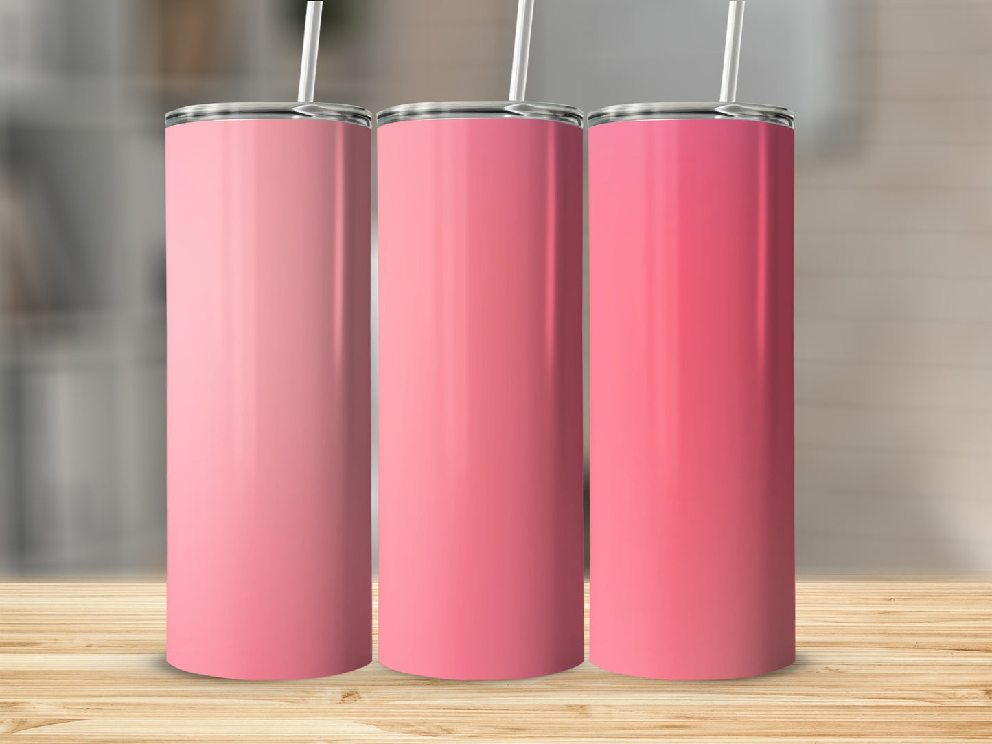 Three pink tumblers with straws stand on a wooden surface.
