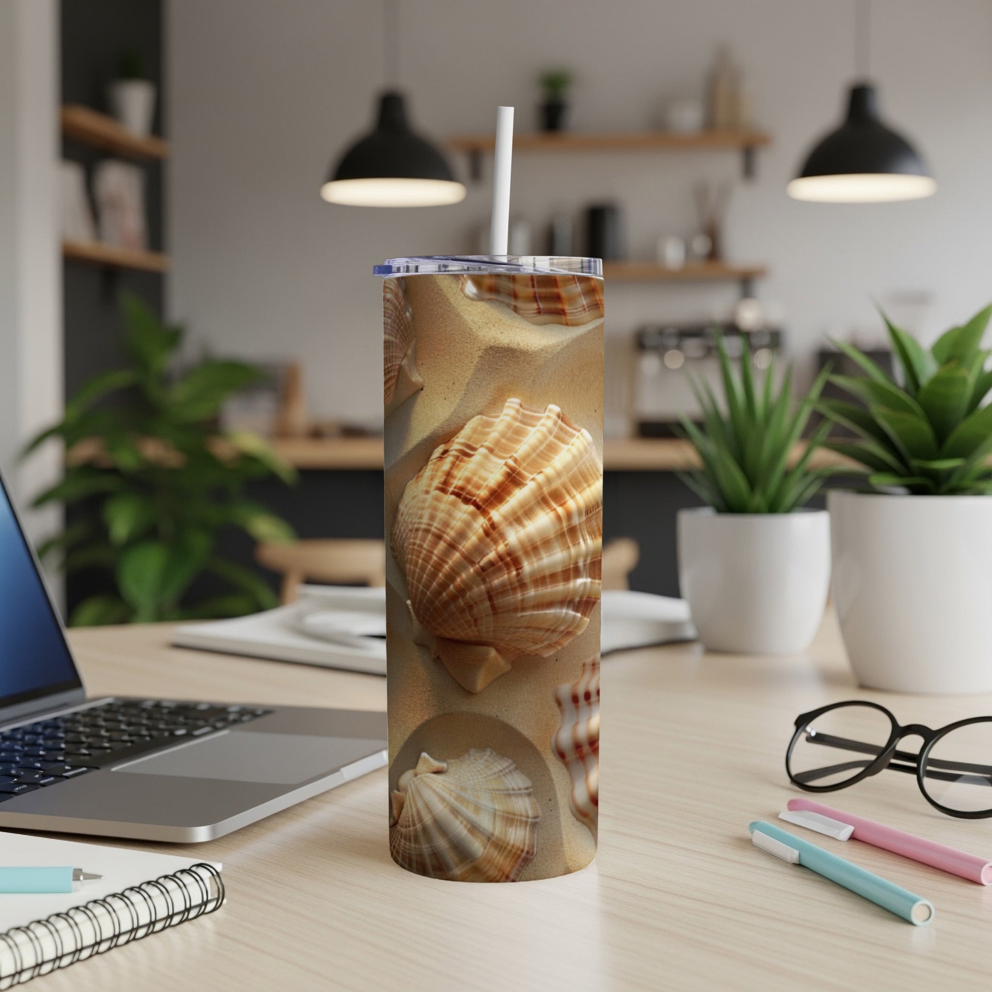Beach seashells on a sandy surface, a straw in a tumbler.
