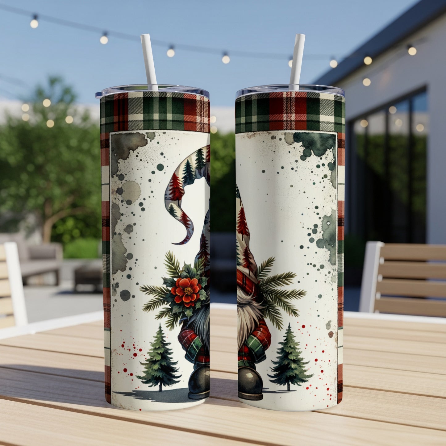 Two tumblers with Christmas gnome and plaid design on an outdoor table.