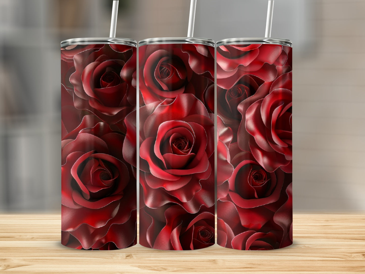 Three tumblers with a red rose floral pattern on a wooden surface.