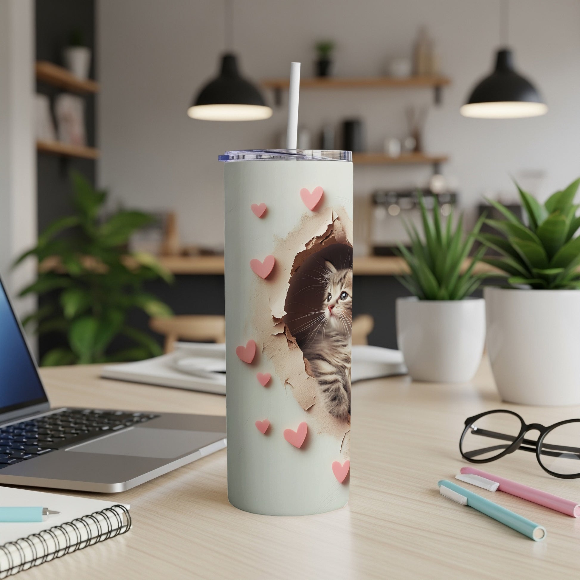 White tumbler with kitten peeking through paper and pink hearts.