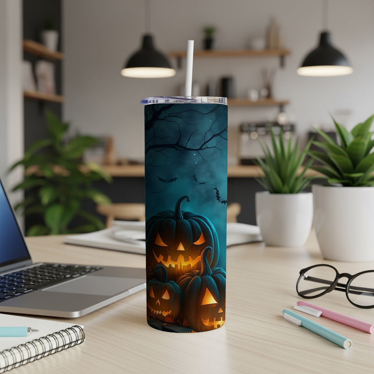 Tumbler with carved pumpkins, bats, and bare trees on a dark, spooky background.