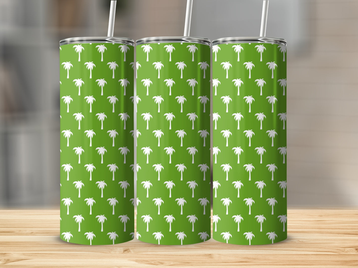 Three green tumblers with white palm tree pattern and straws.