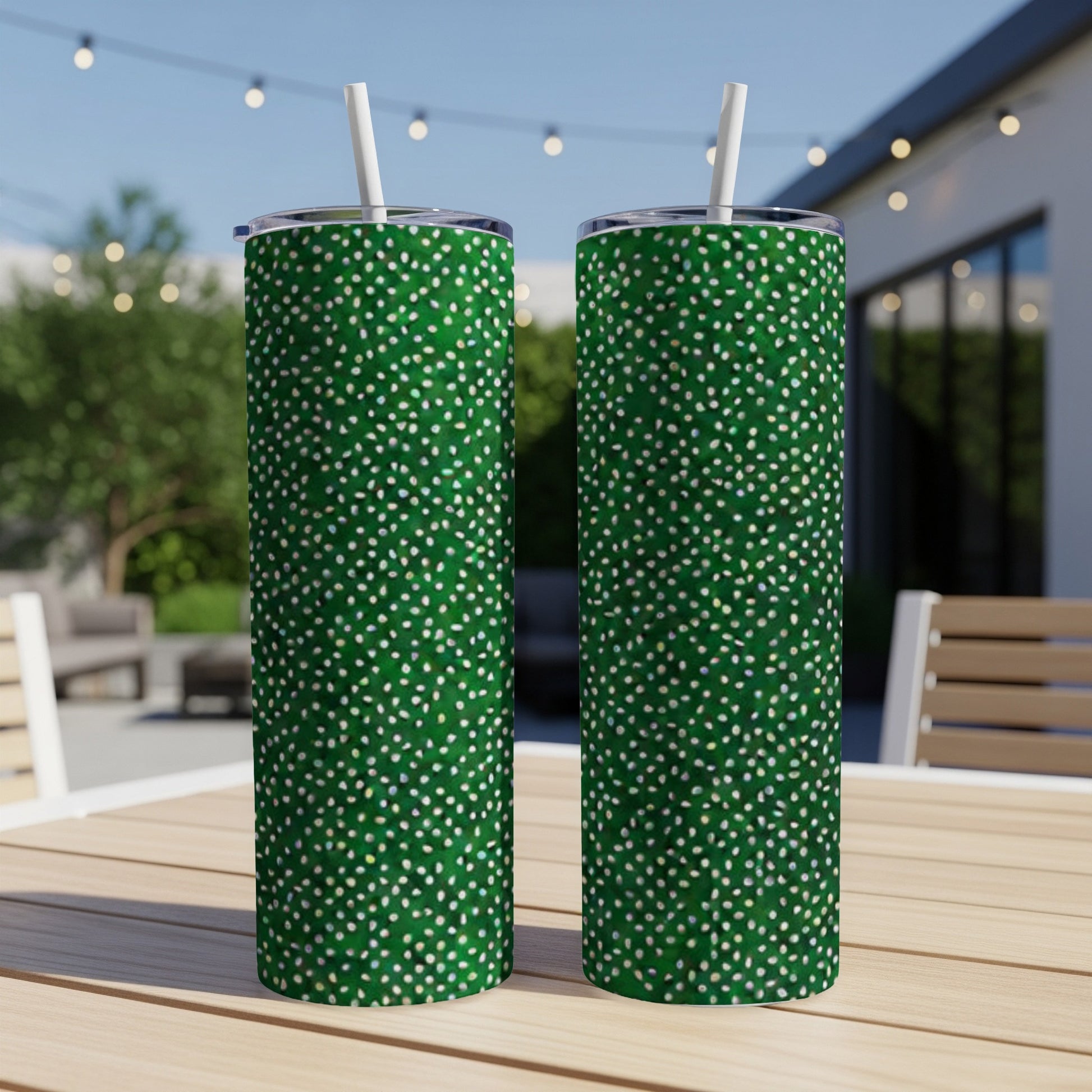 Two green tumblers with white and gold speckled pattern on a table.