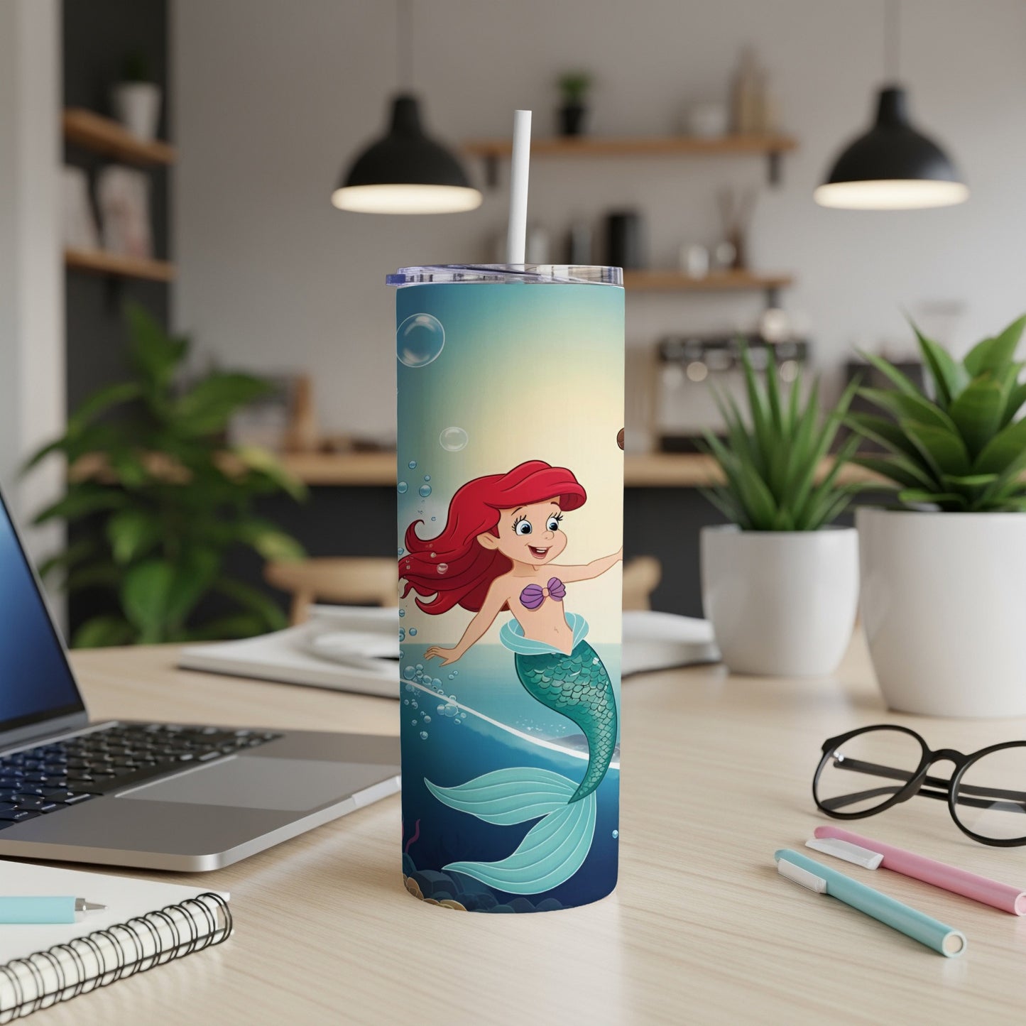 Ariel the Little Mermaid in a blue and green tail on a tumbler.