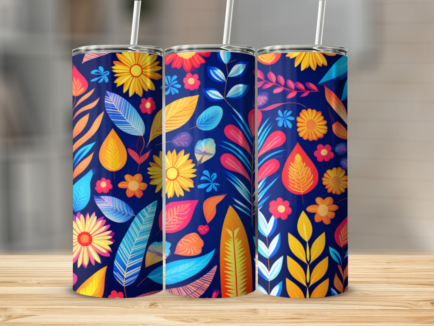 Three tumblers with a colorful floral and leaf pattern on a wooden surface.