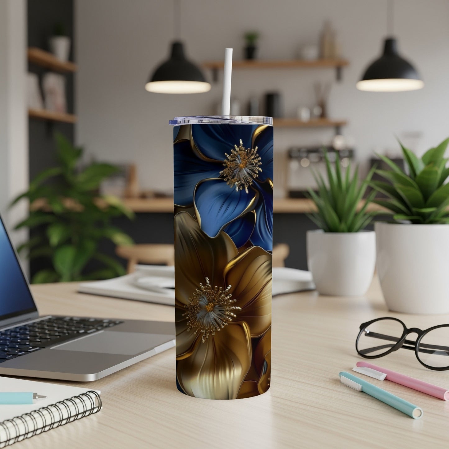 Gold and blue floral design on a skinny tumbler with a straw.