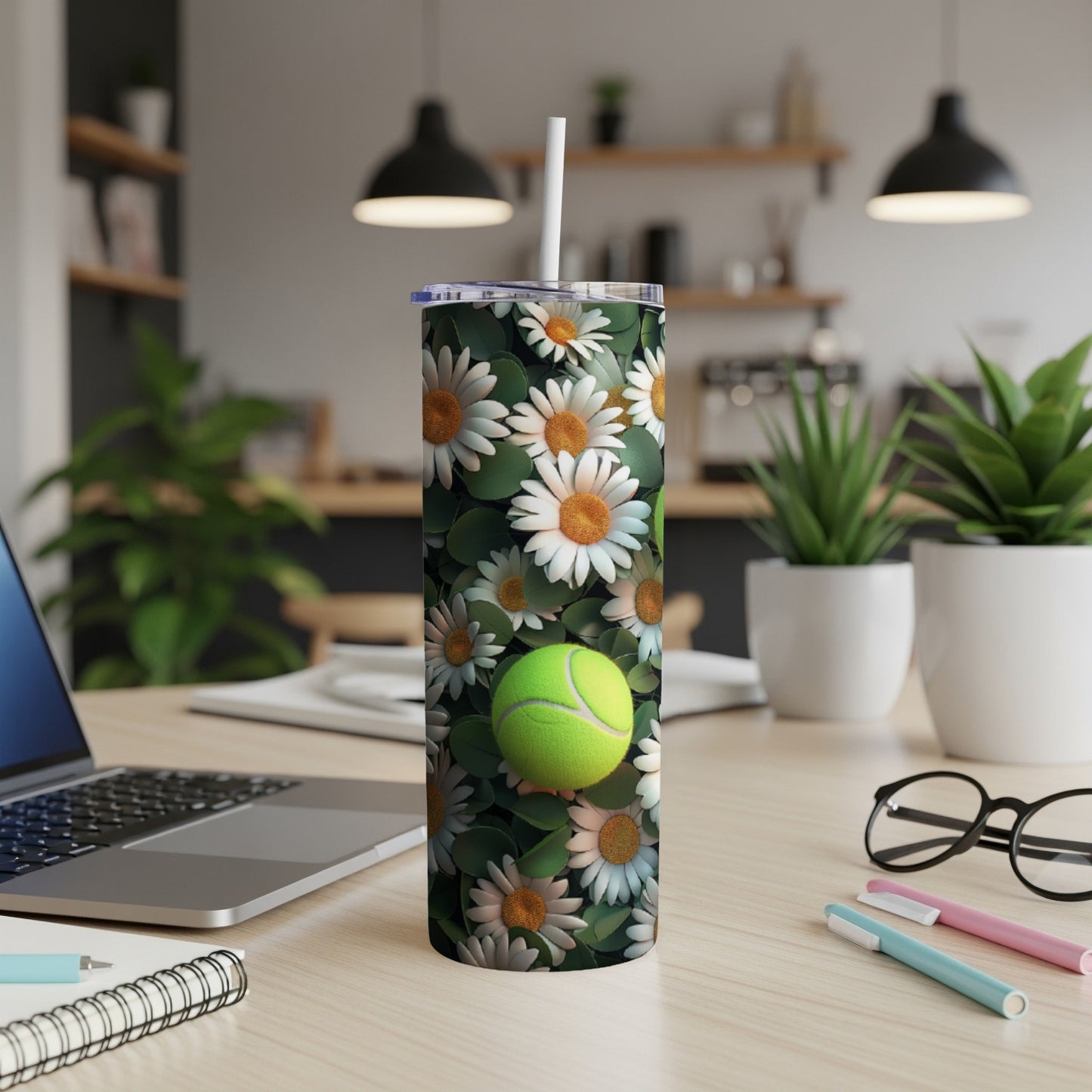 Tumbler with daisies and a tennis ball design.