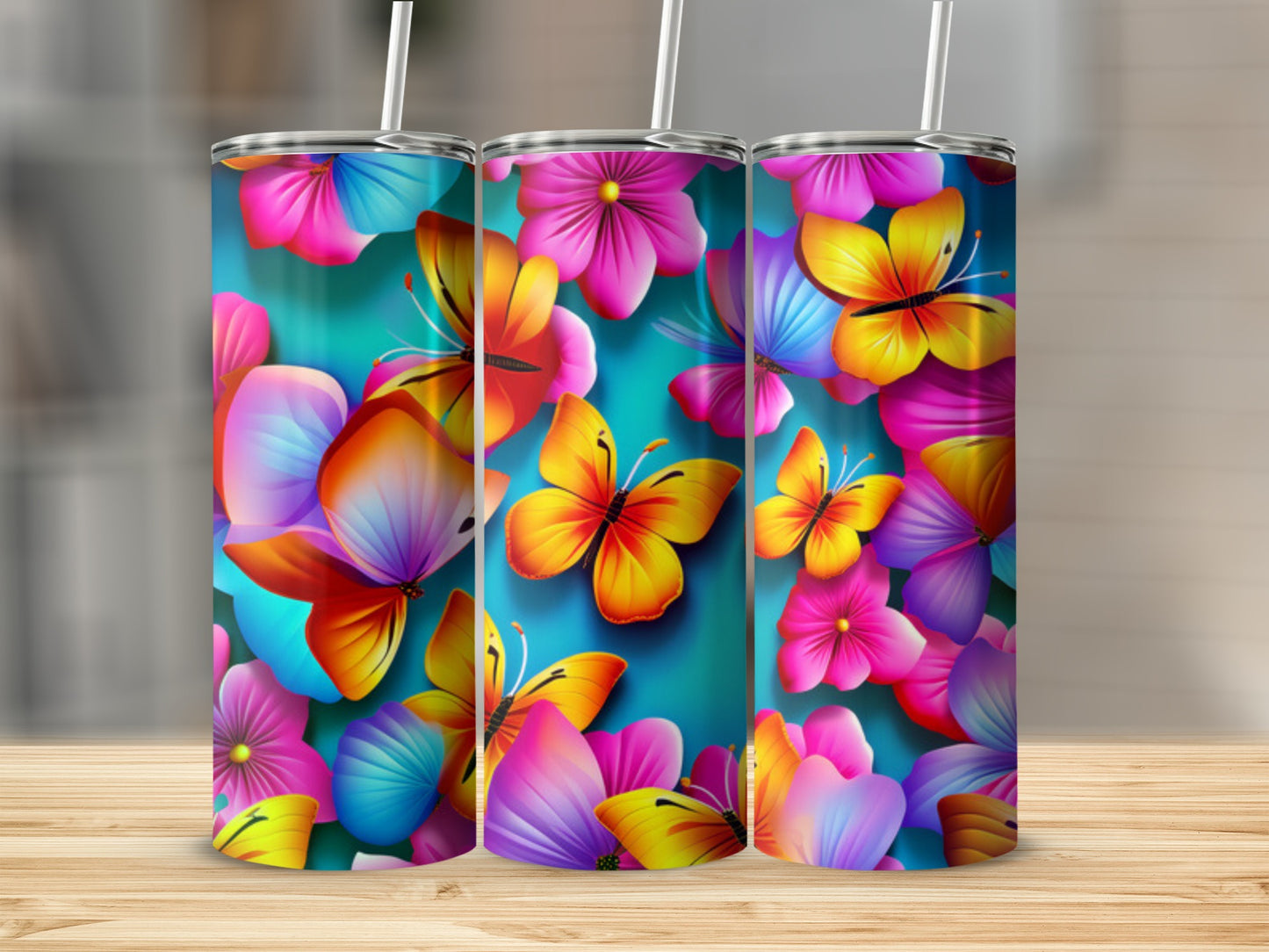 Three tumblers with colorful butterflies and floral patterns on a wooden surface.