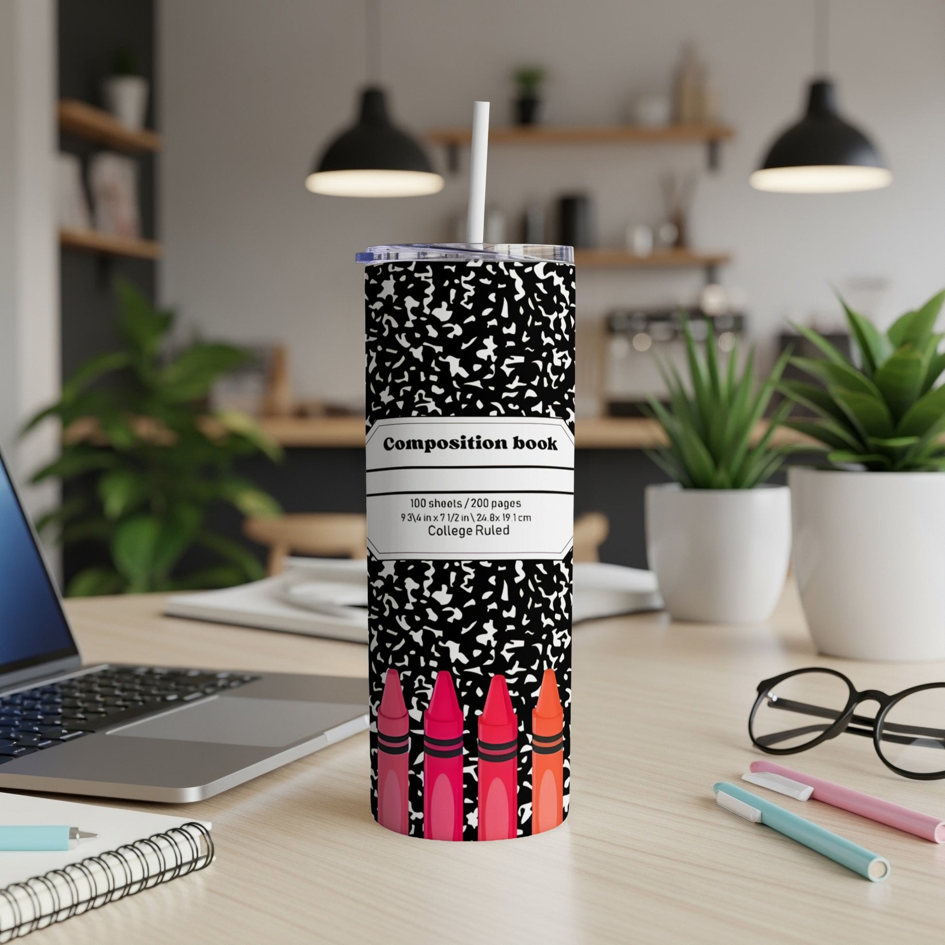 Composition book tumbler with colorful crayons and white lid.