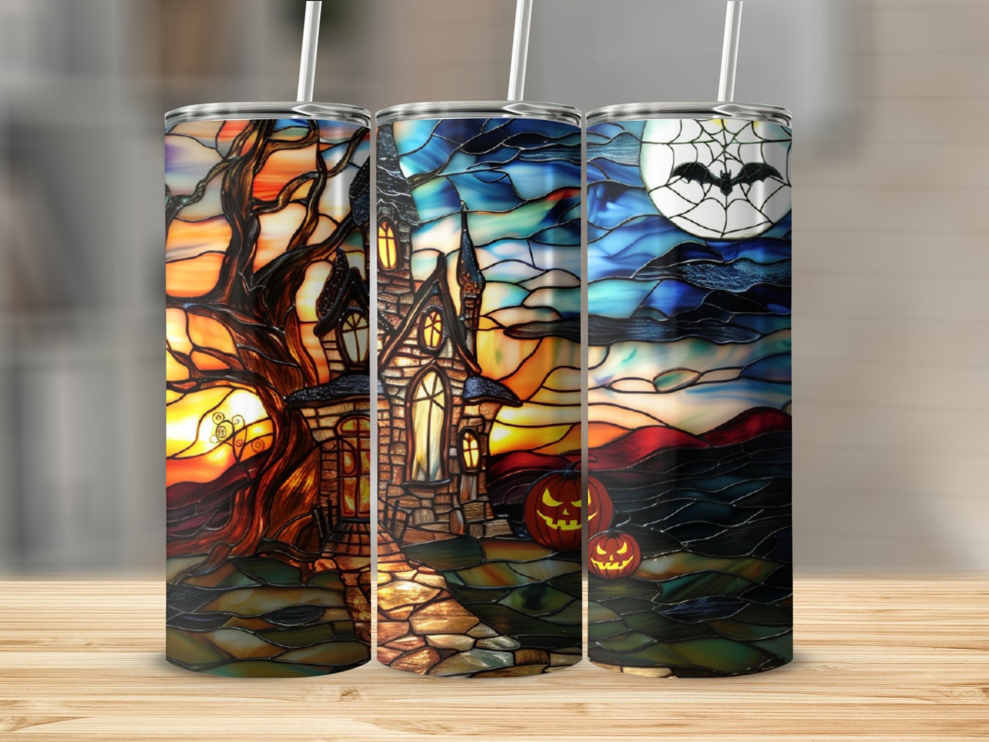 Three Halloween-themed tumblers with stained glass artwork of haunted houses and spooky scenes.