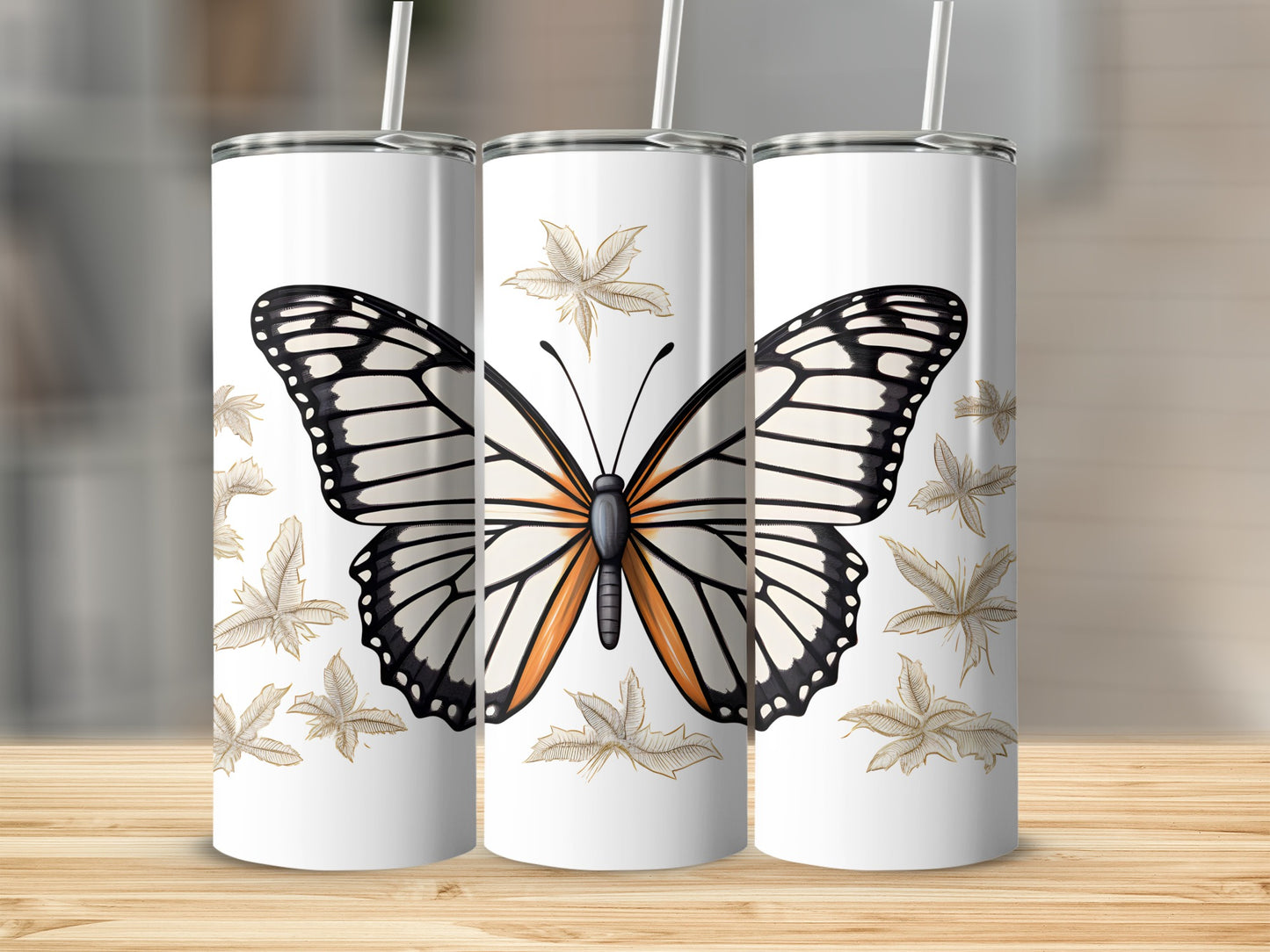 Three white tumblers with a black, orange, and white butterfly and falling leaves design.