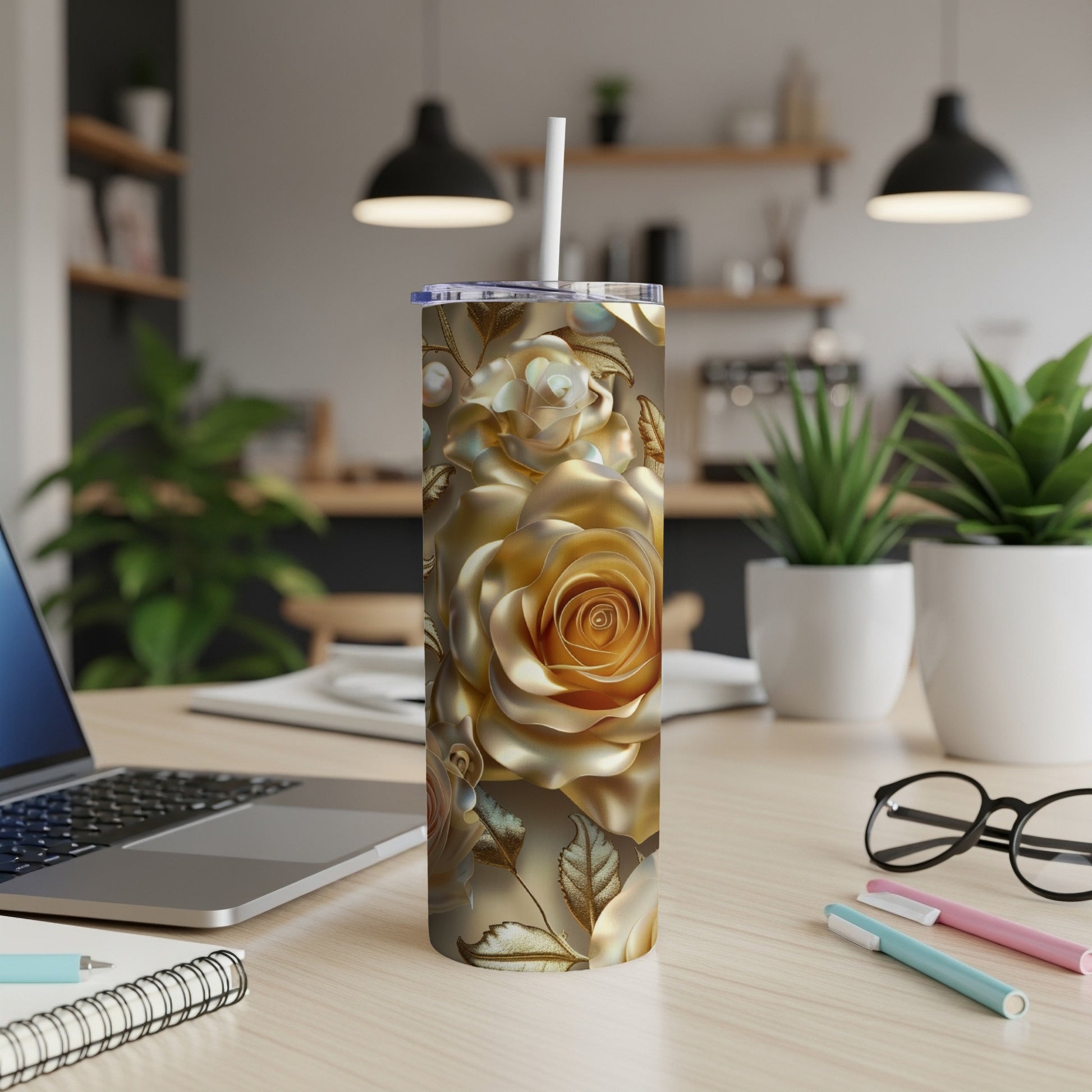 Gold floral tumbler with a white straw on a desk.