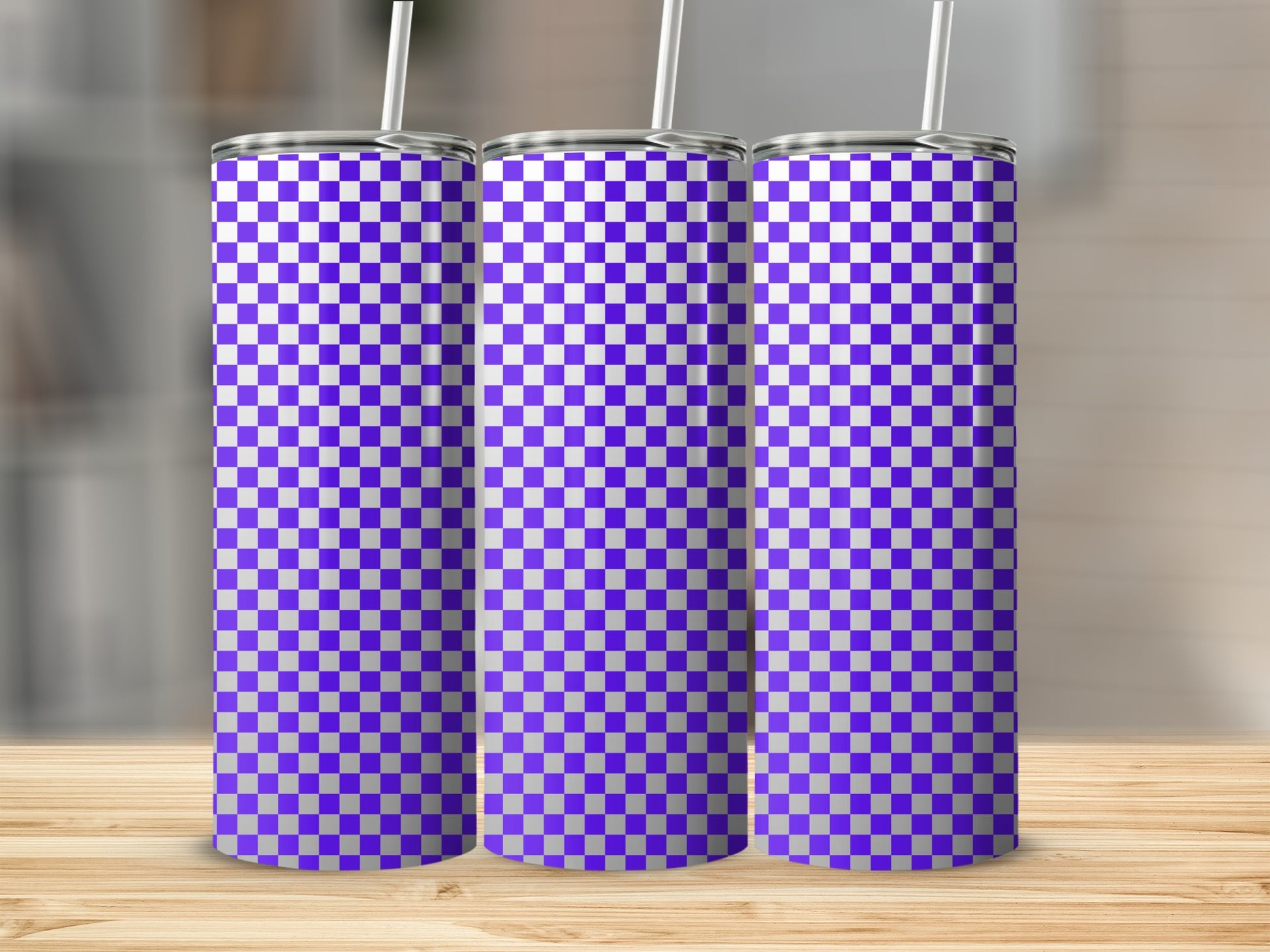 Three tall purple and white checkered tumblers with straws stand on a wooden surface.