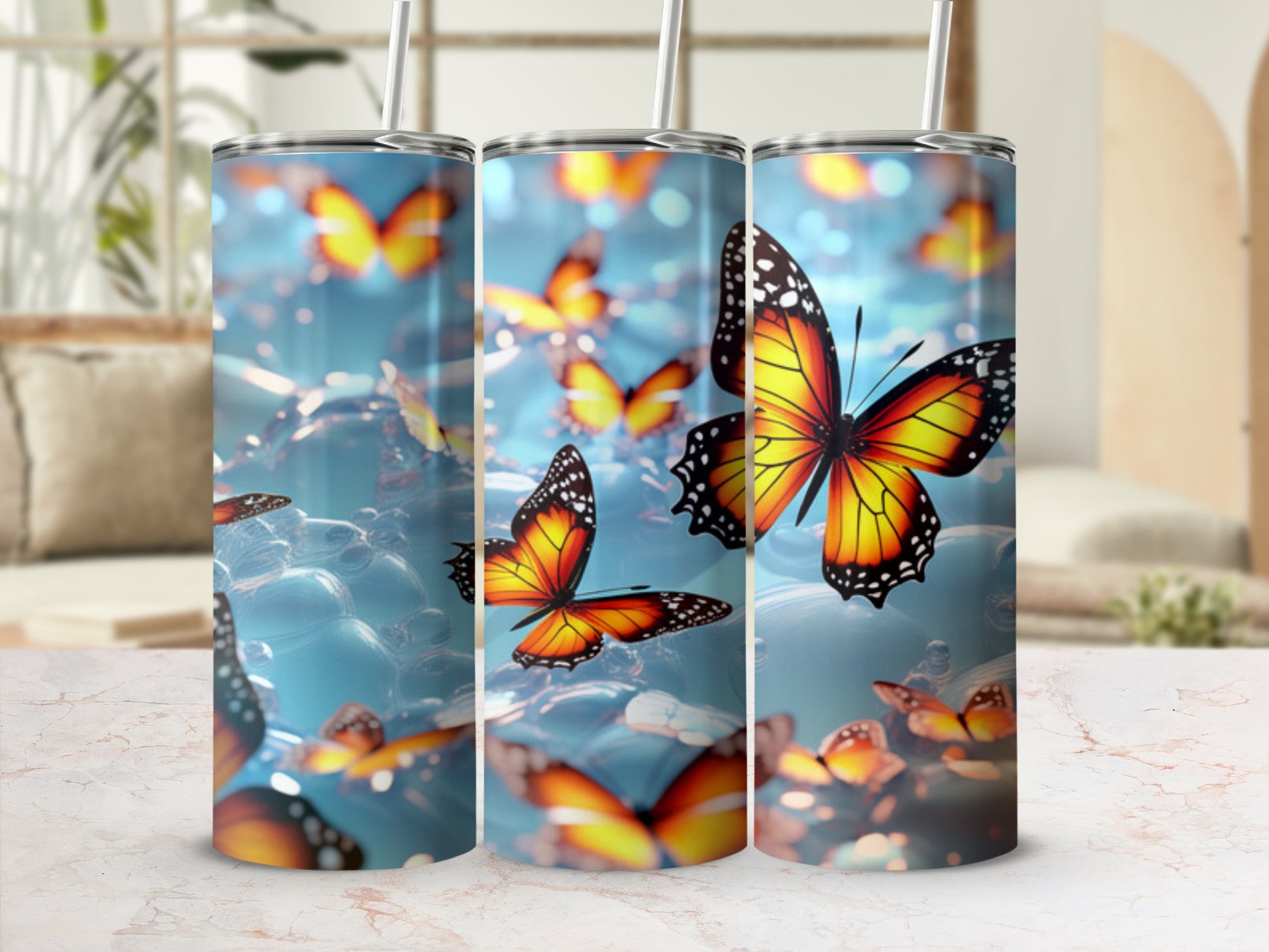 Three tumblers with a vibrant orange butterfly pattern against a blurry blue background.