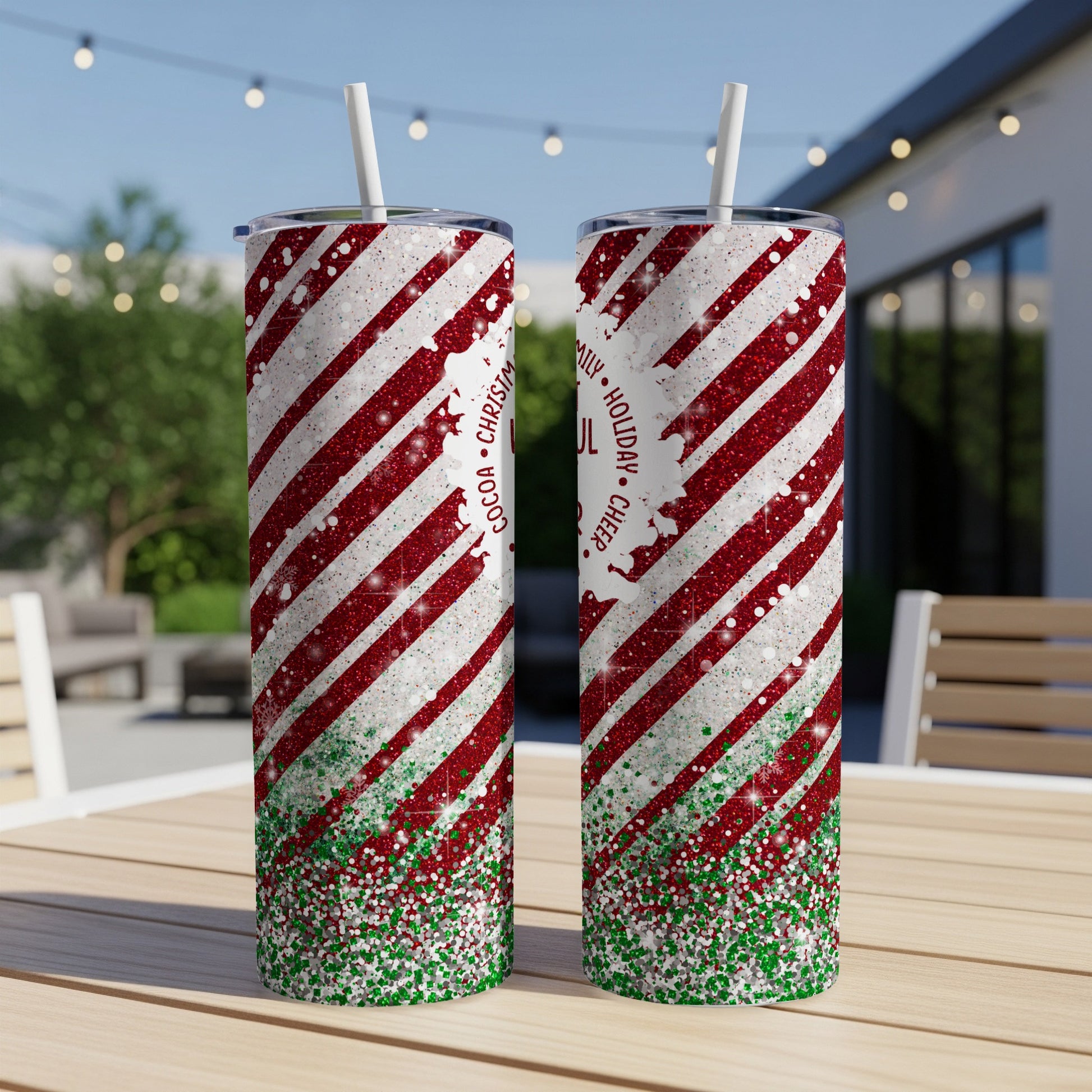 Two glittery red and white striped tumblers with "Holiday Cheer" text on a table.