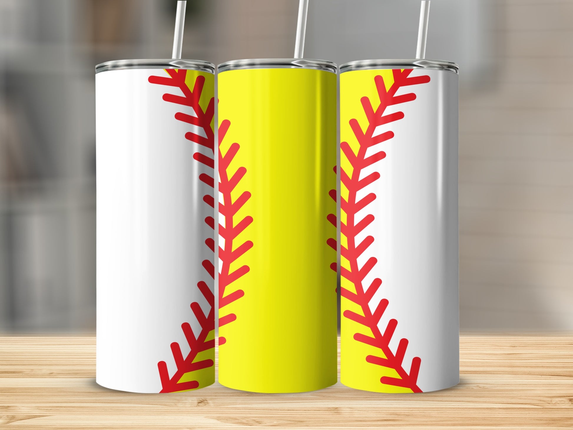 Three tumblers designed to look like softballs on a wooden surface.
