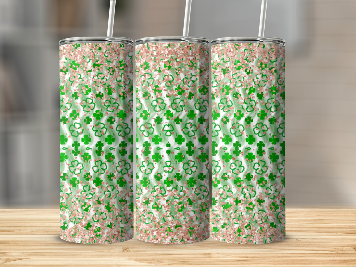 Three tall tumblers with a green clover and rose gold glitter pattern.