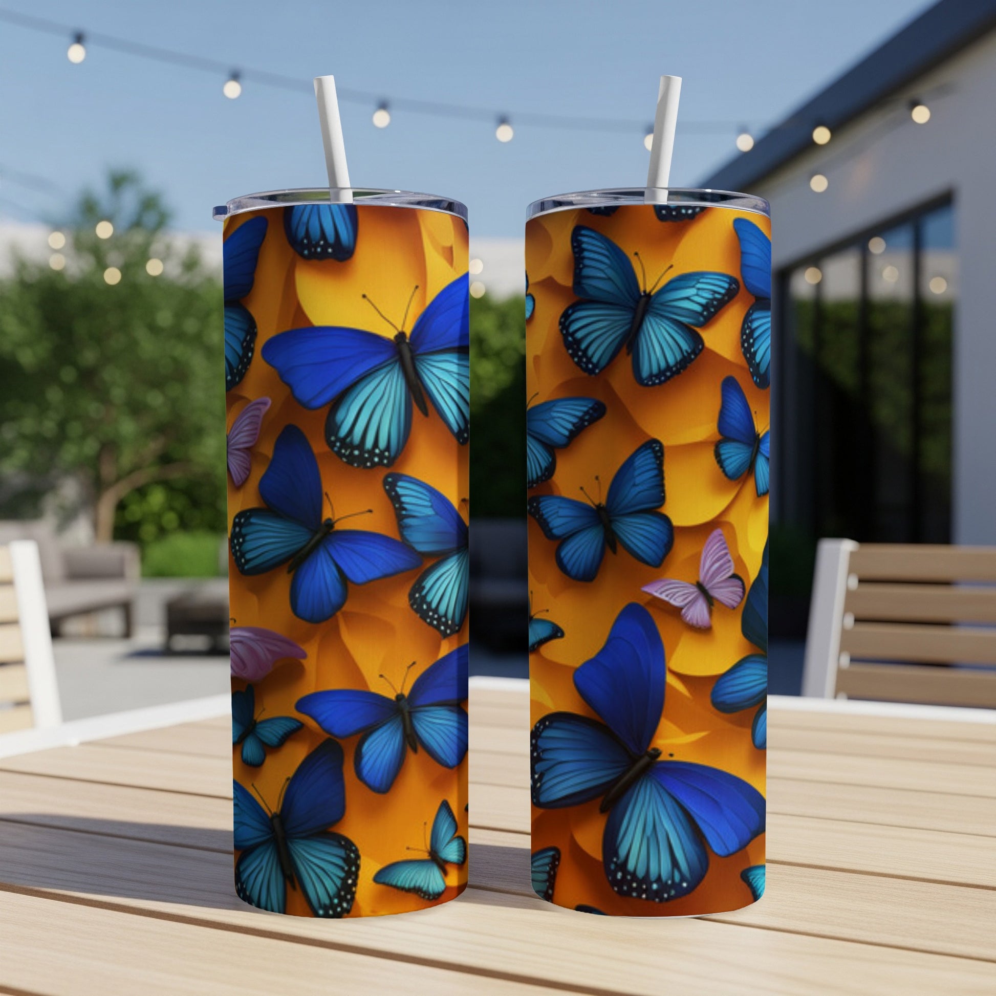 Two tall tumblers with blue butterflies on a vibrant orange background.