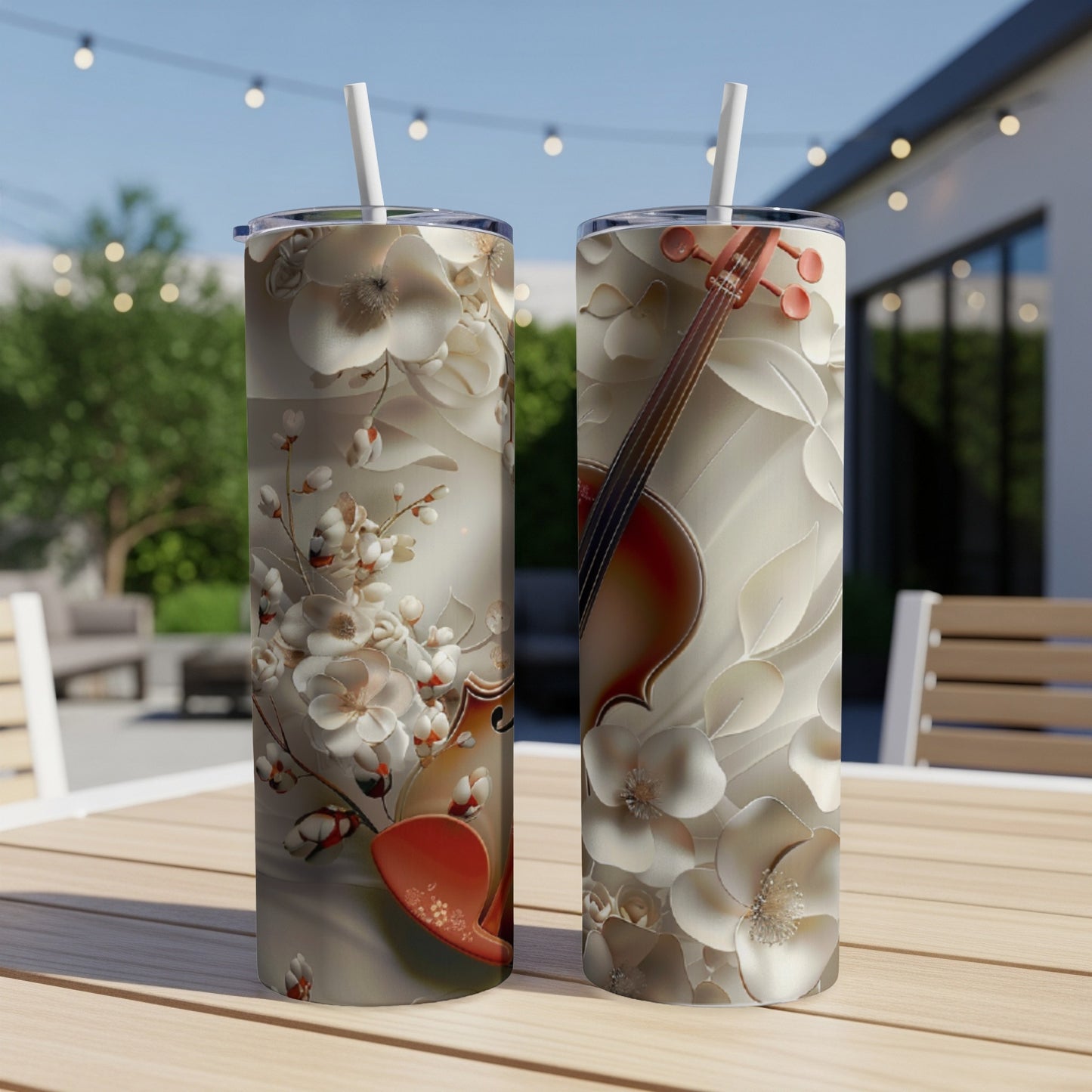 Two tall tumblers with floral and violin designs on a table.