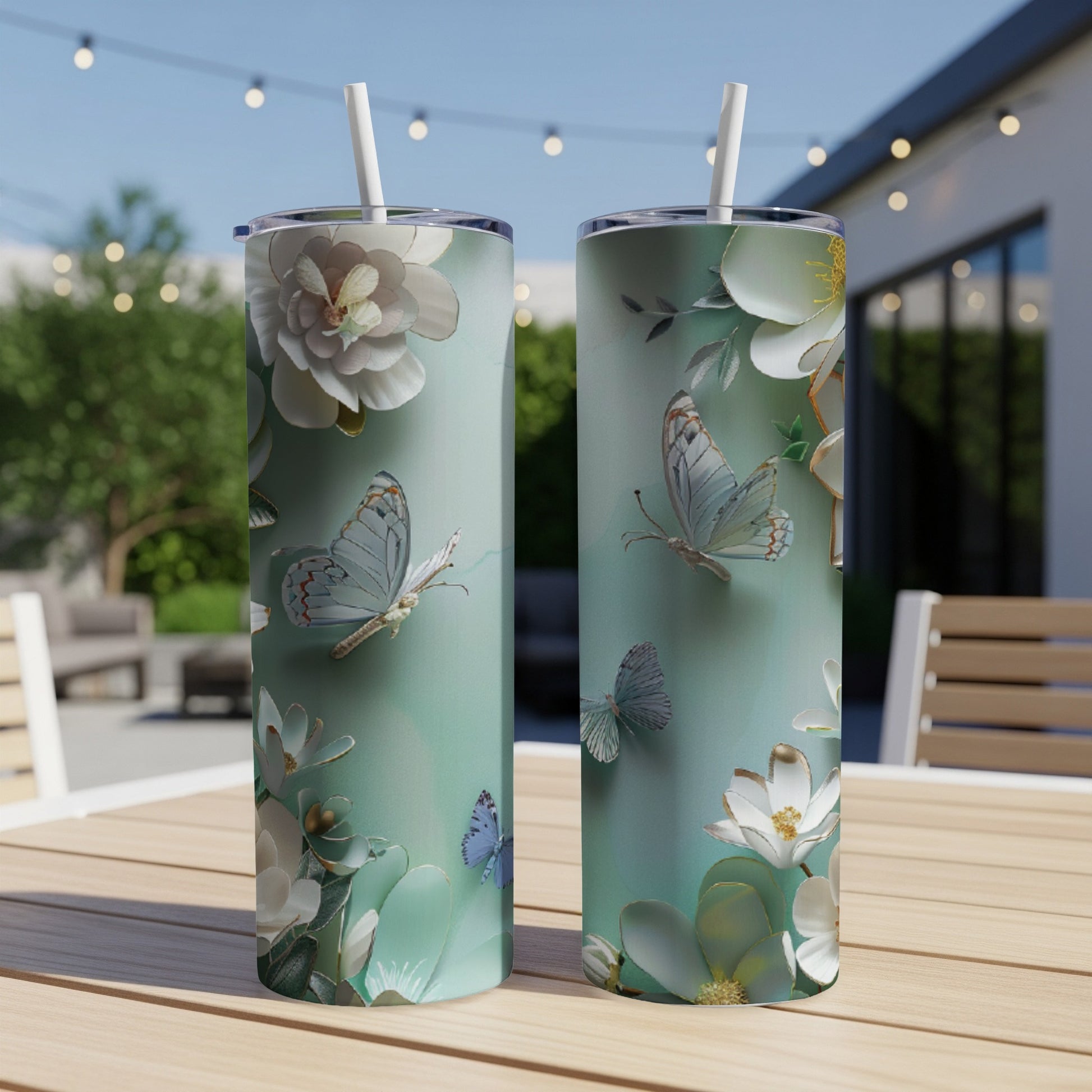 Two teal tumblers with white butterflies and floral illustrations.