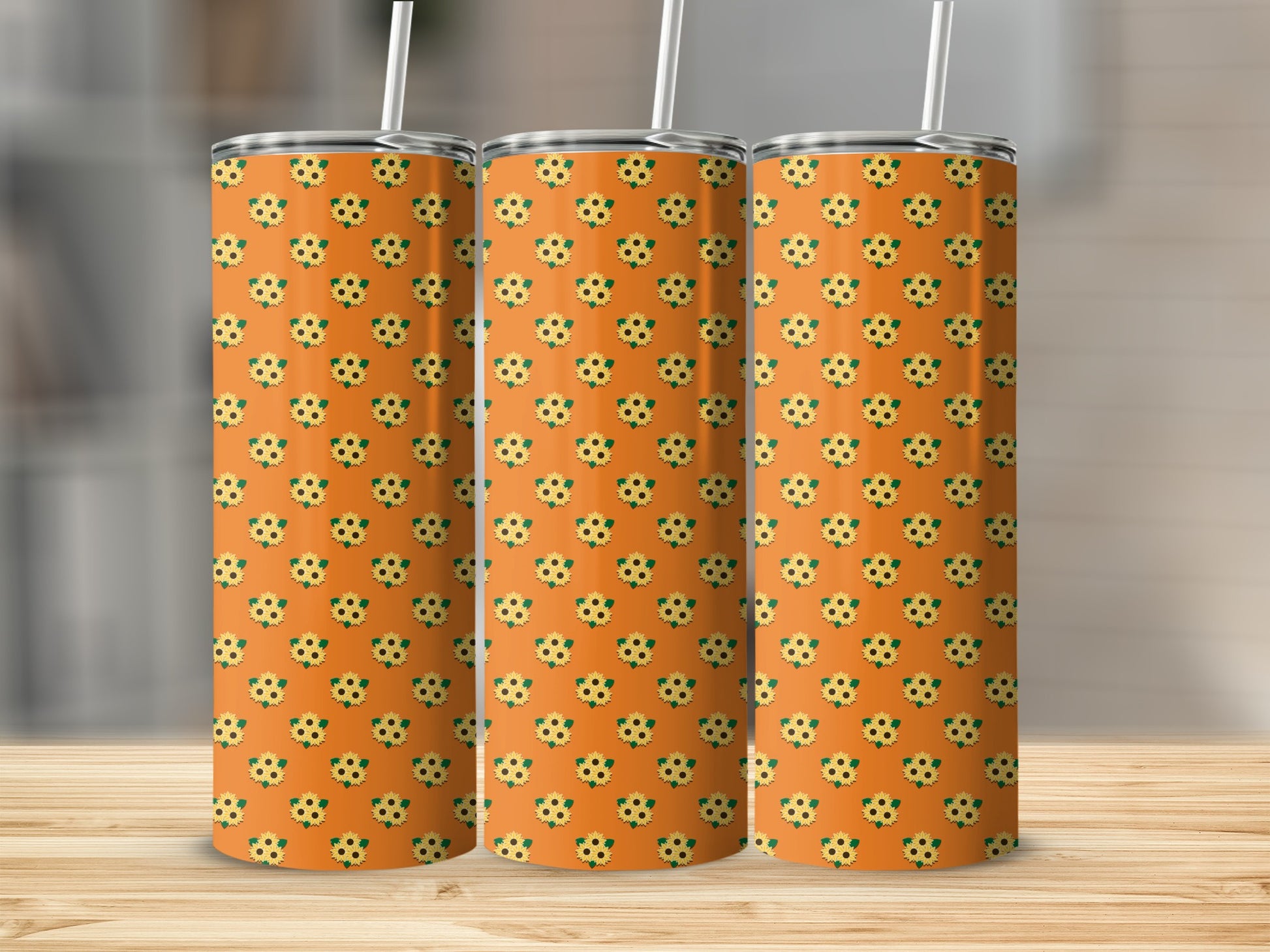 Three tumblers with a repeating sunflower pattern on an orange background.