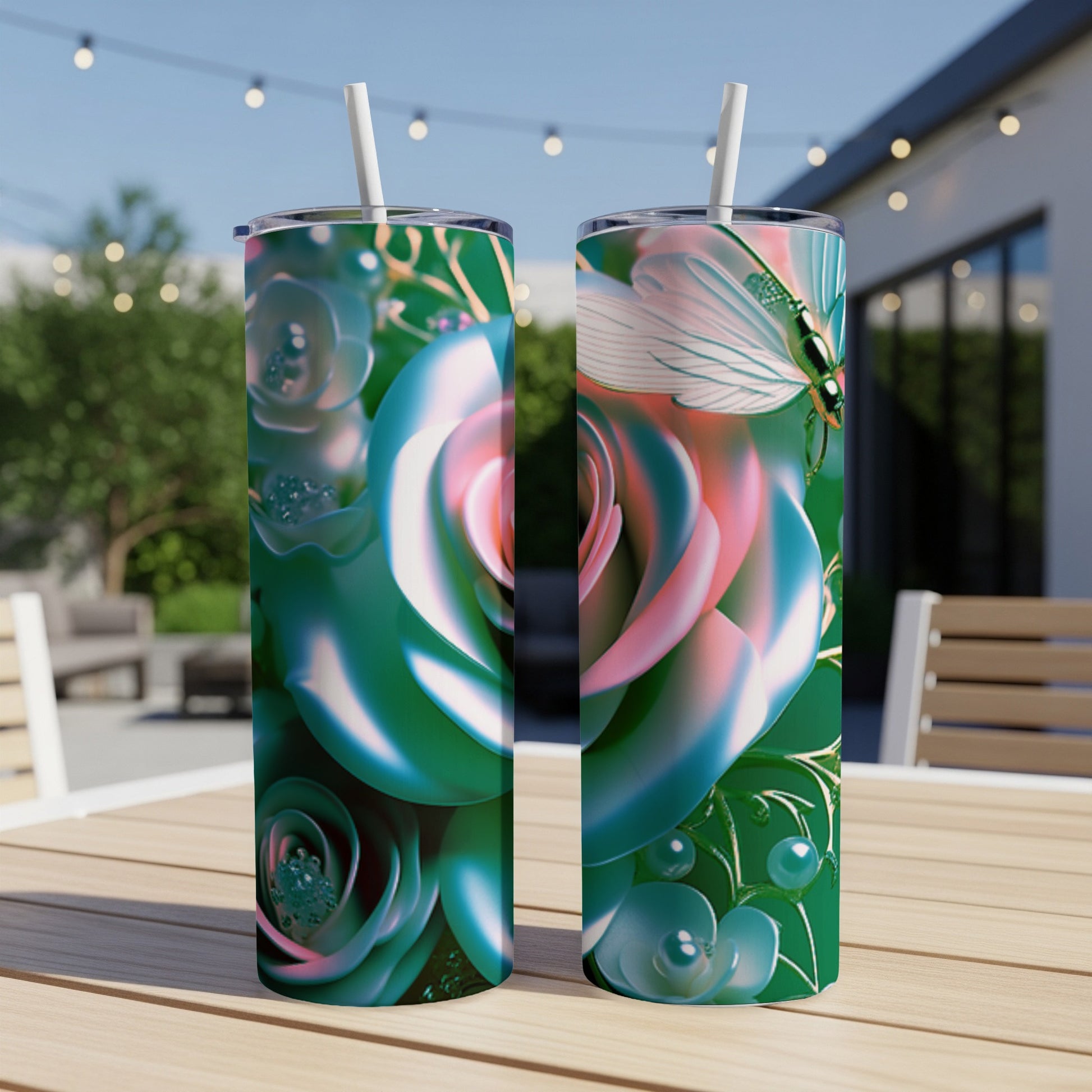 Two green tumblers with pink roses and dragonflies, on a wooden table outdoors.