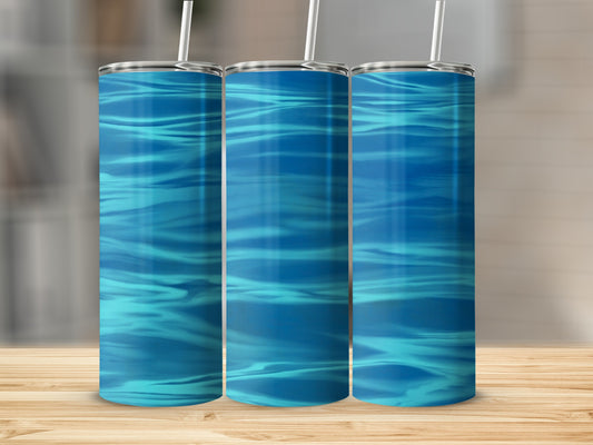 Three tumblers with rippling blue water design on a wooden surface.