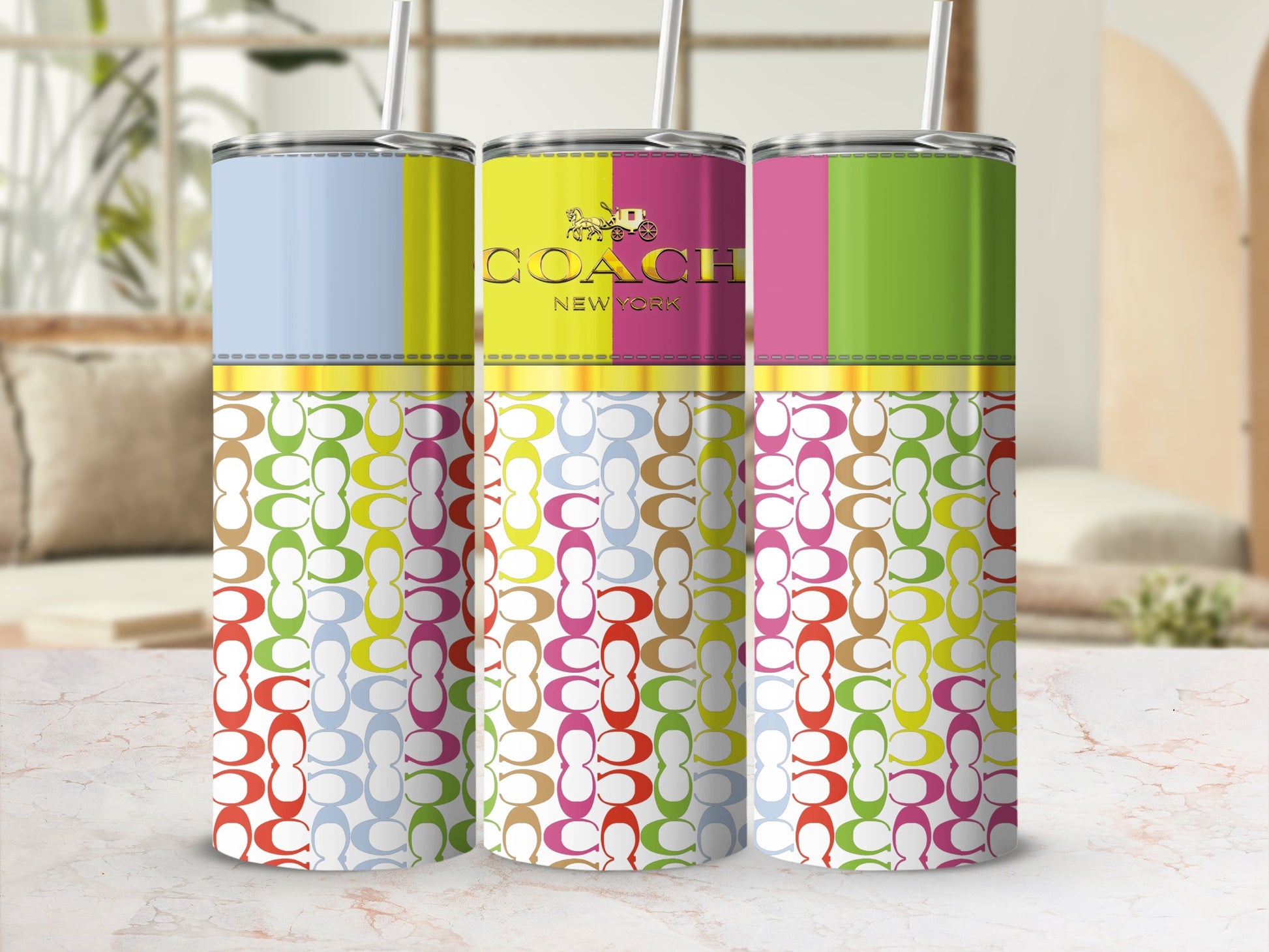 Three Coach New York tumblers with colorful patterned designs and straws.
