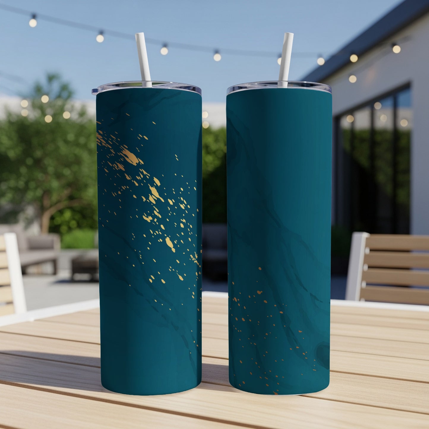 Two teal tumblers with gold speckle and marble designs, outdoors.