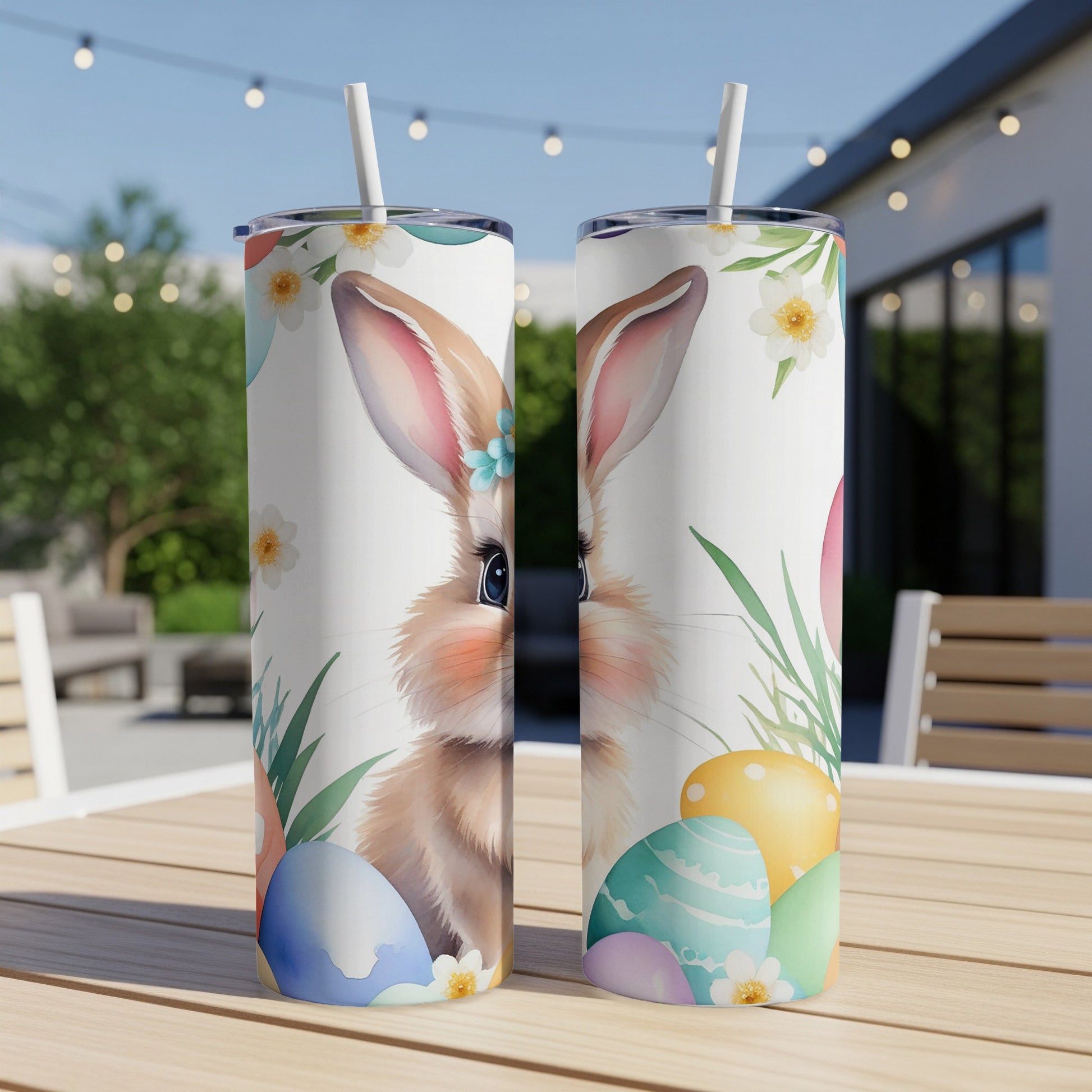 Easter bunny and painted eggs on two tumblers on a table.