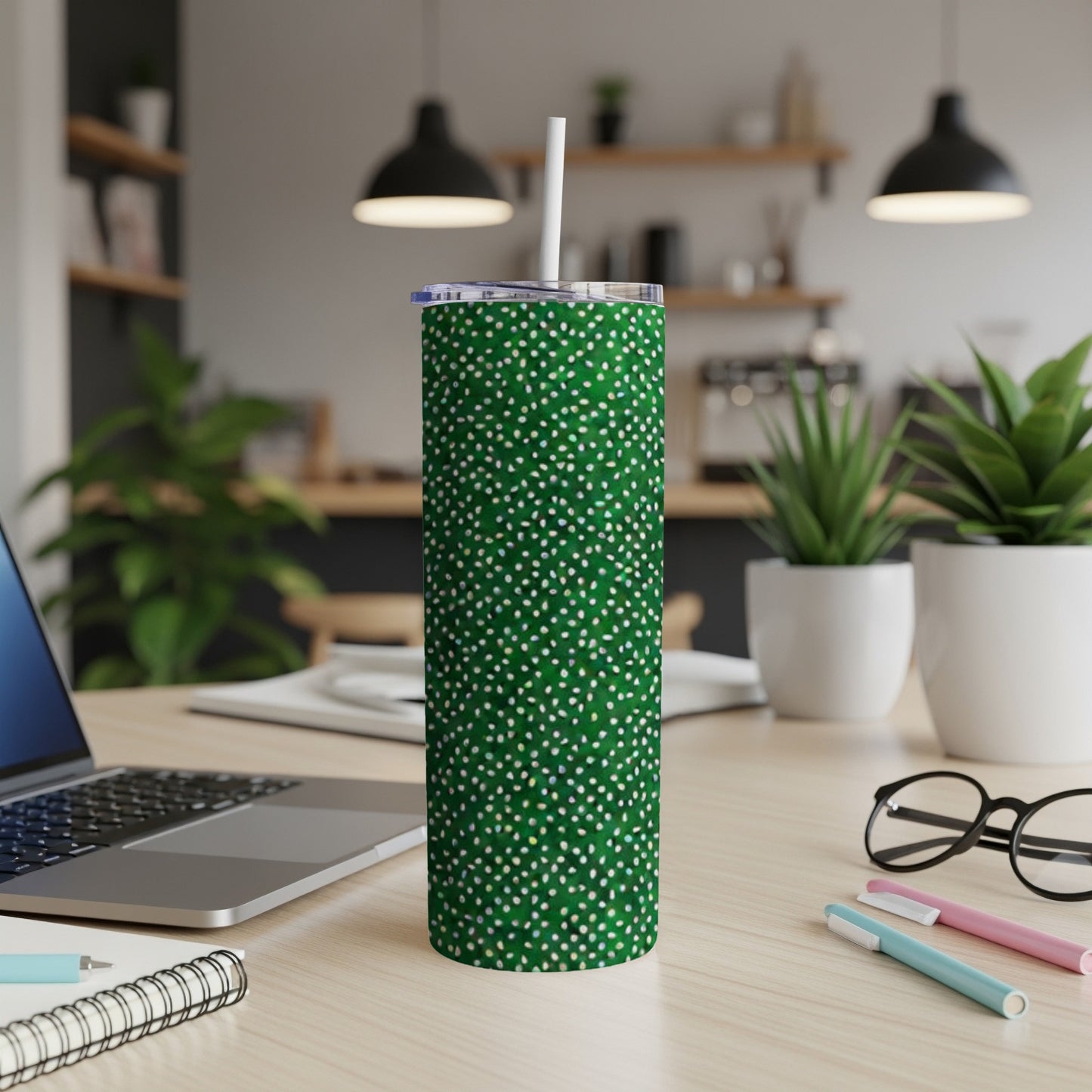 Green speckled tumbler with a white straw on a desk.