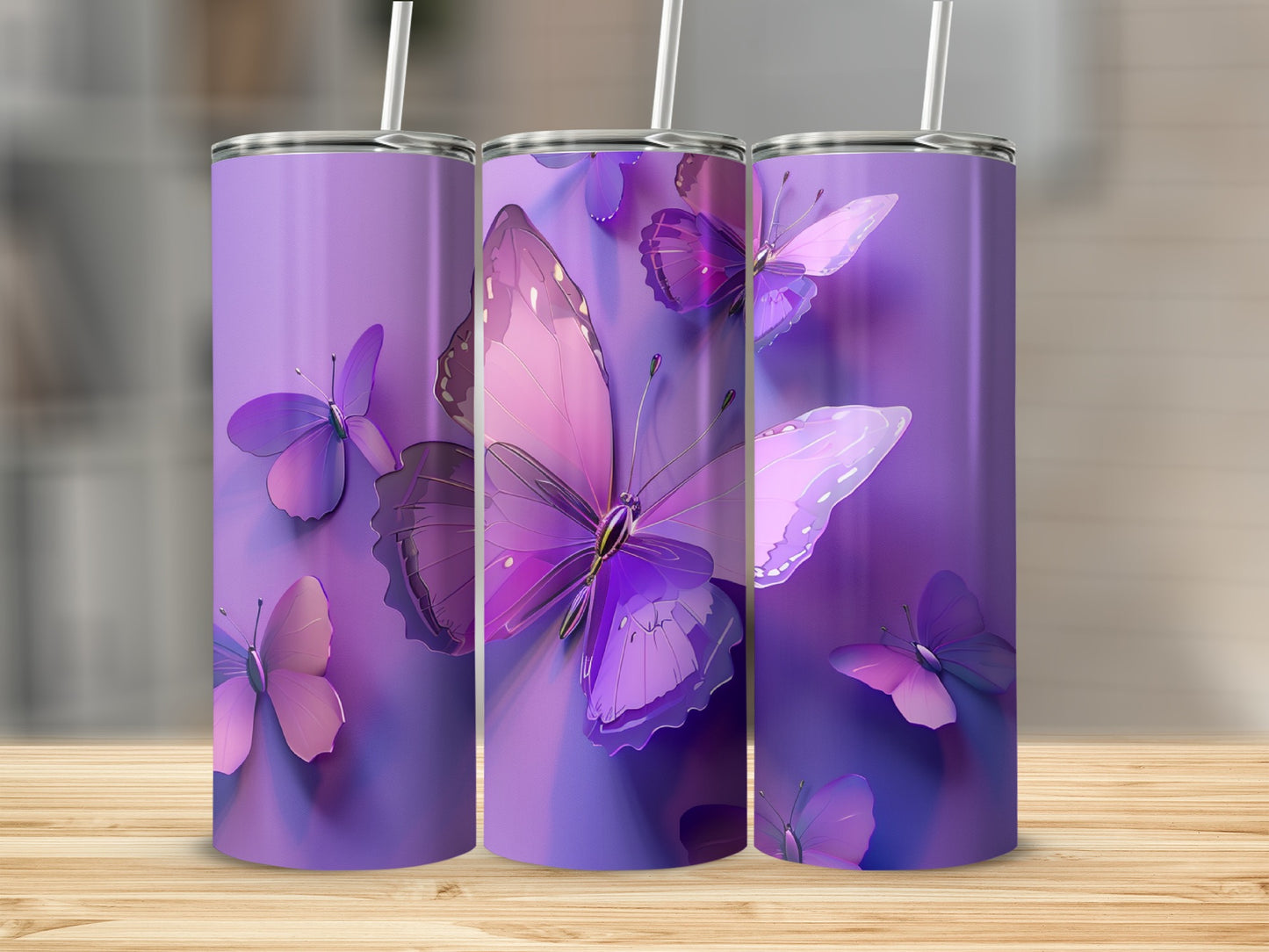 Three purple tumblers with butterfly designs on a wooden surface.