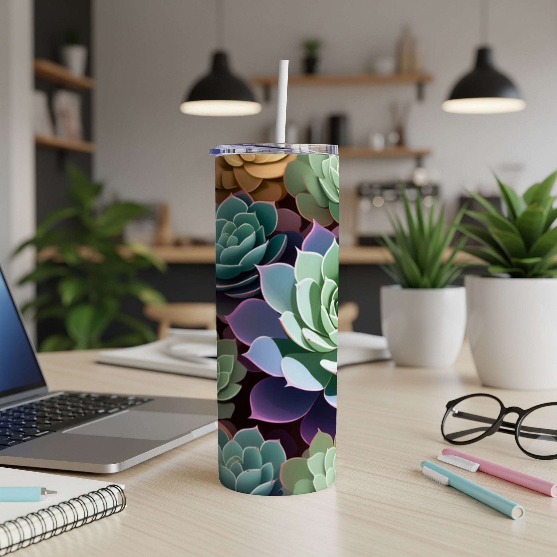 Tumbler with colorful succulent plant pattern on a desk with laptop.