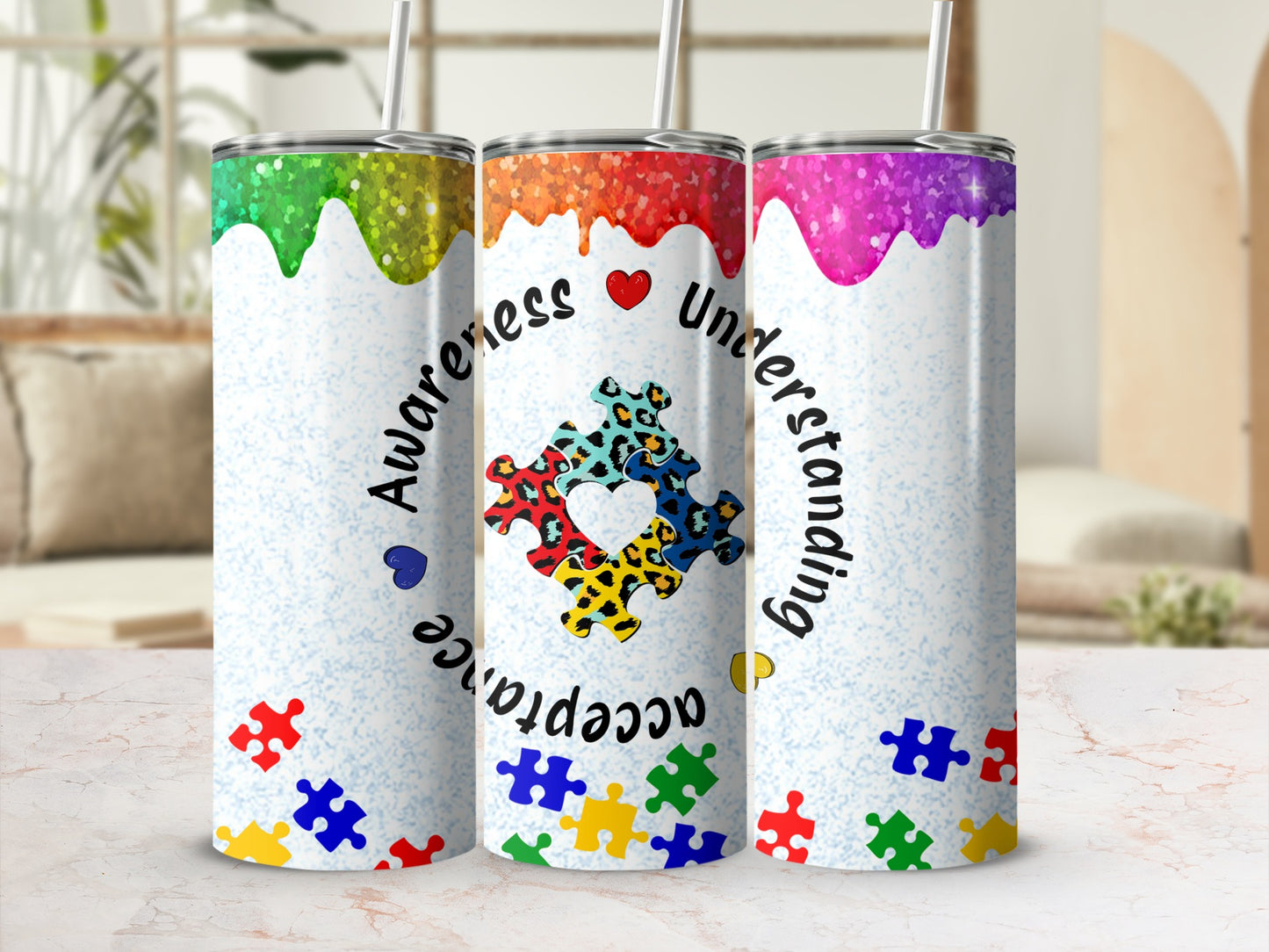 Three glitter tumblers with autism awareness puzzle piece design and text.
