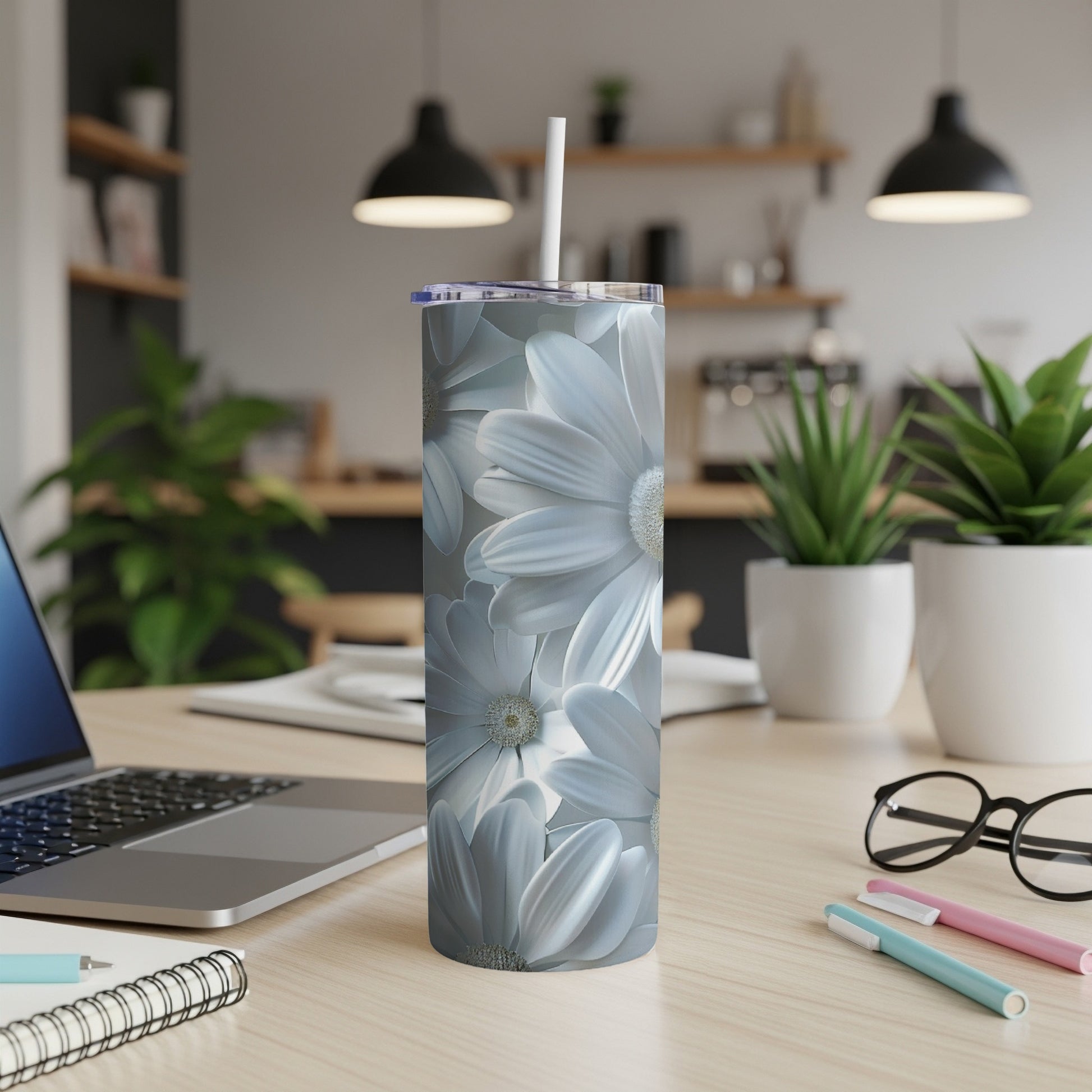 White daisy floral pattern on a silver tumbler with a straw.