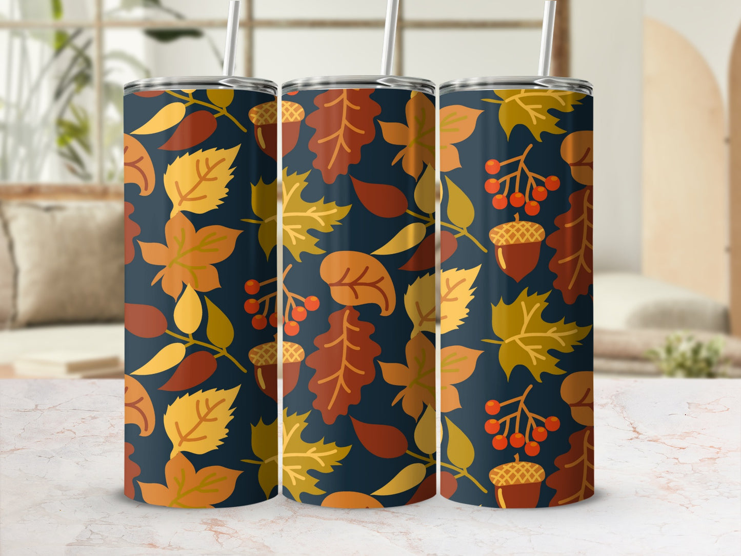 Three tumblers with a repeating pattern of fall leaves and acorns on a dark background.
