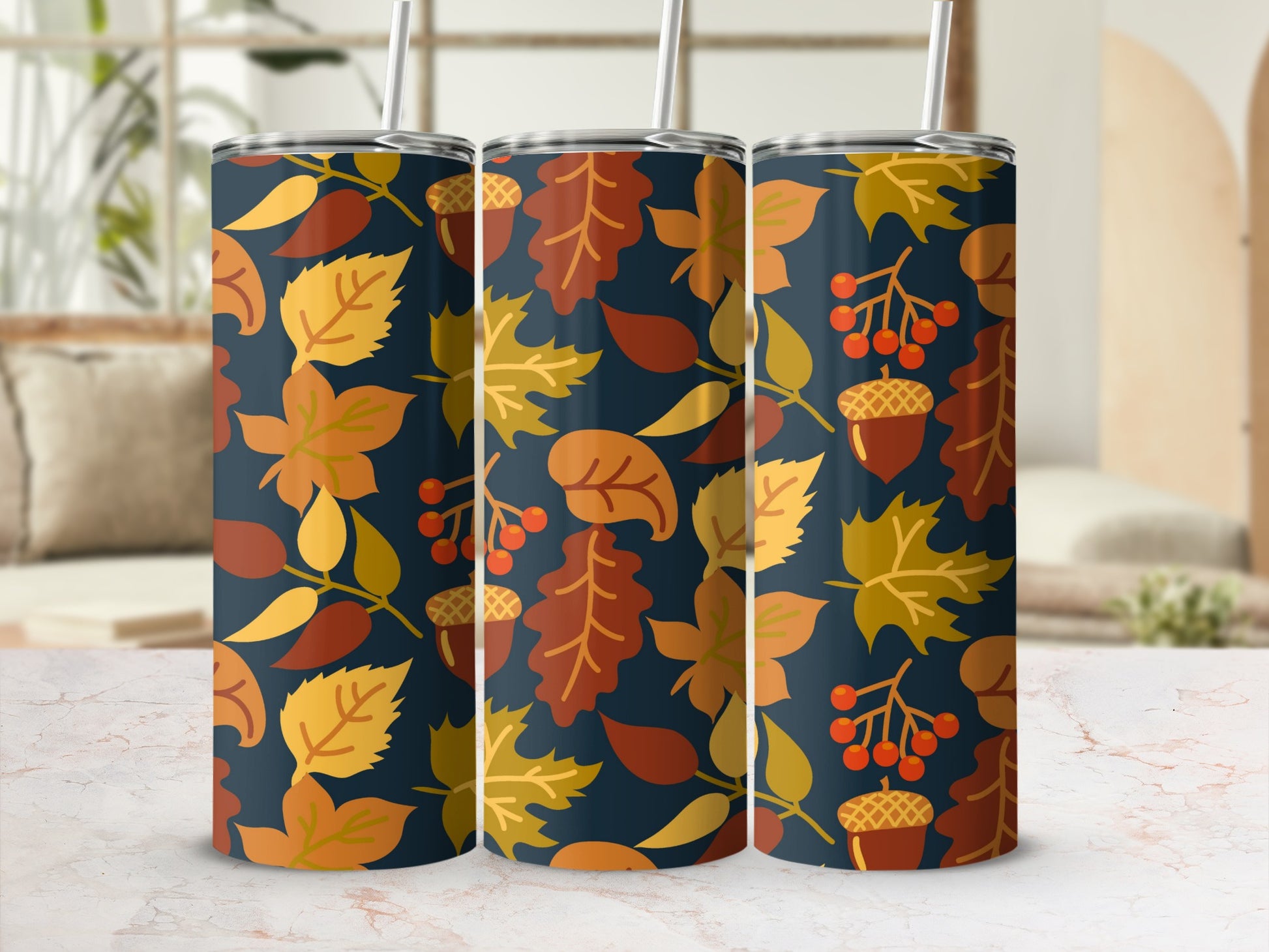 Three tumblers with a repeating pattern of fall leaves and acorns on a dark background.