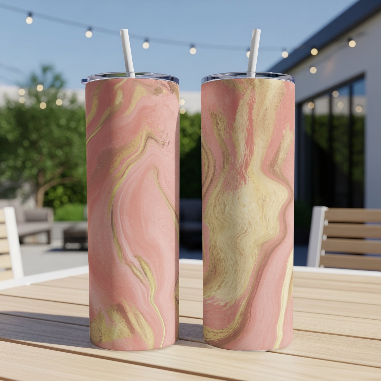 Two tall tumblers with pink and gold marble design sit on a wooden table.