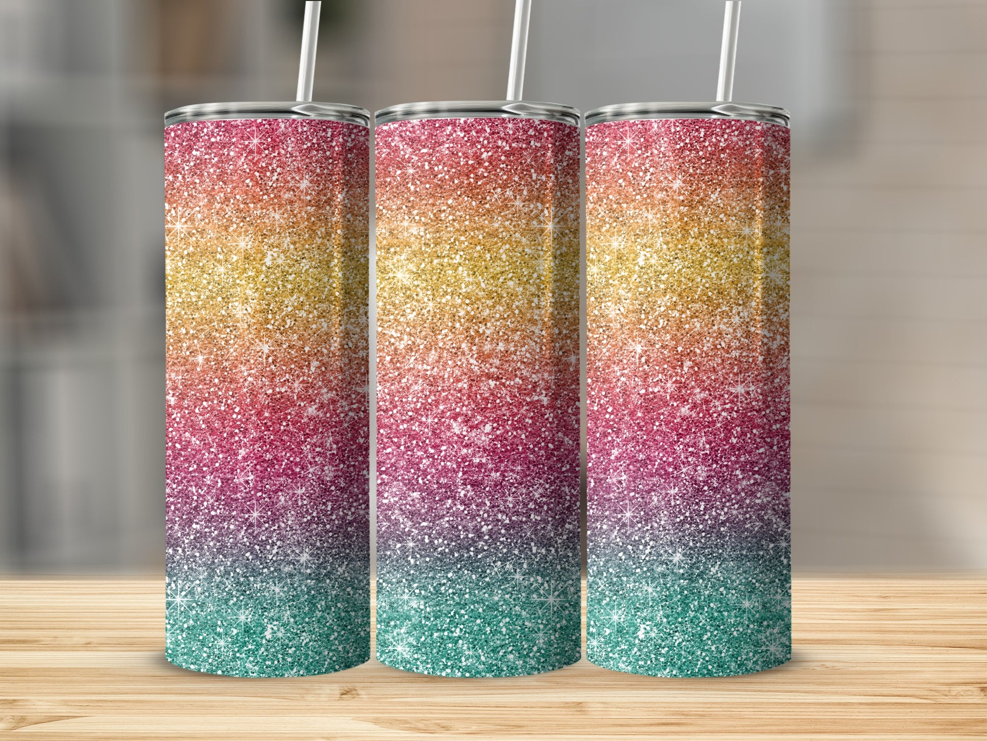 Three glitter tumblers with ombre rainbow design and white straws.