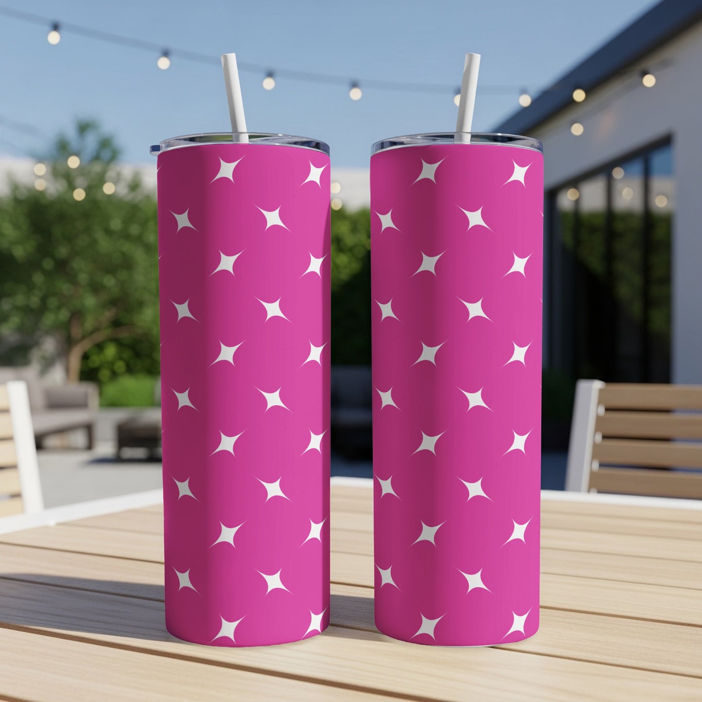 Two pink tumblers with white star pattern, resting on a wooden table.