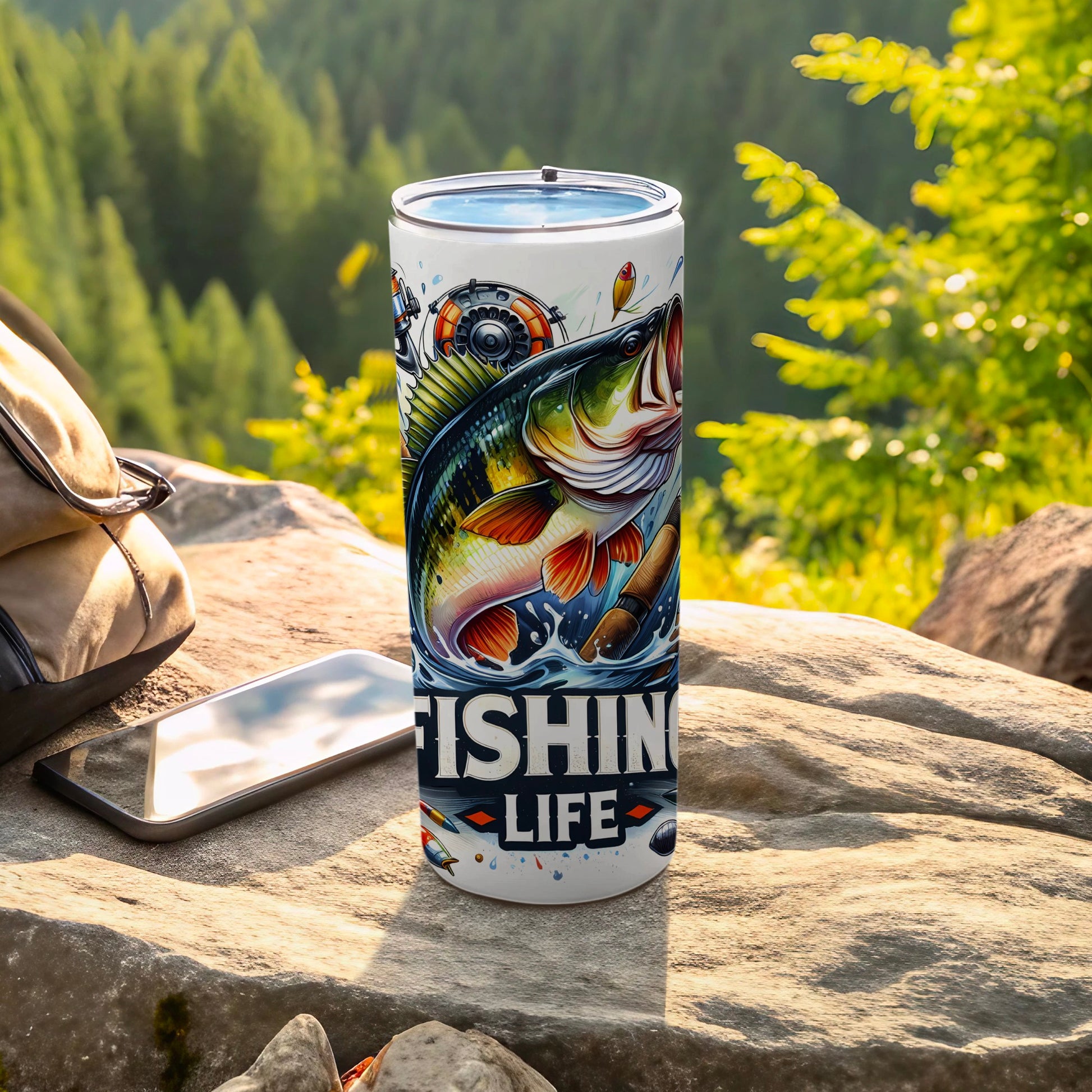Fishing Life tumbler with fish, reel, and lures on a rock.