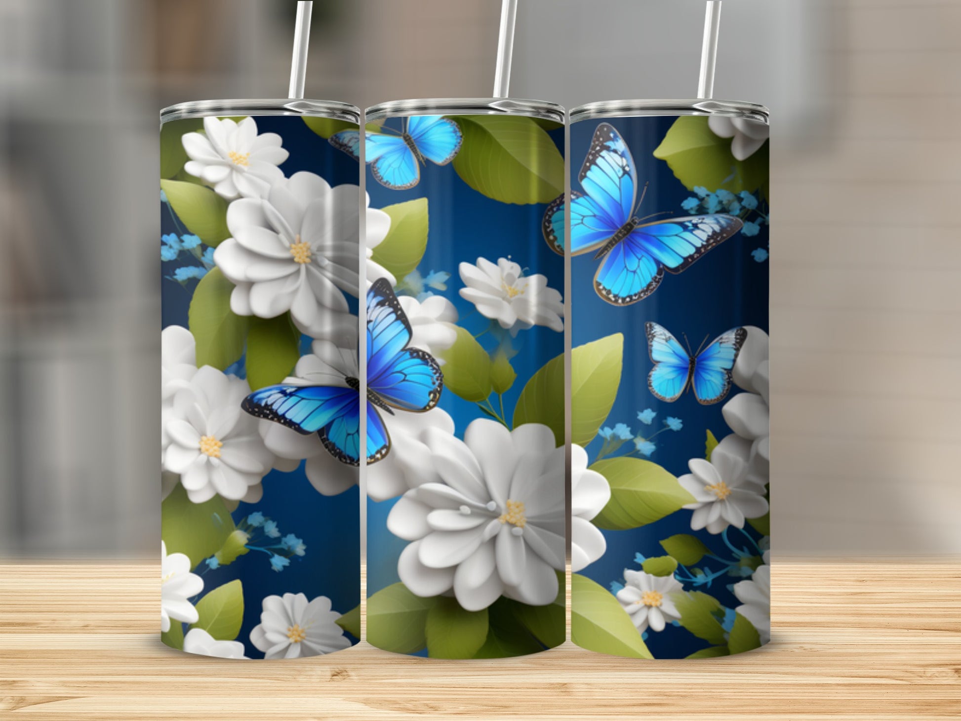 Three tumblers with blue butterflies and white flowers on a dark blue background.