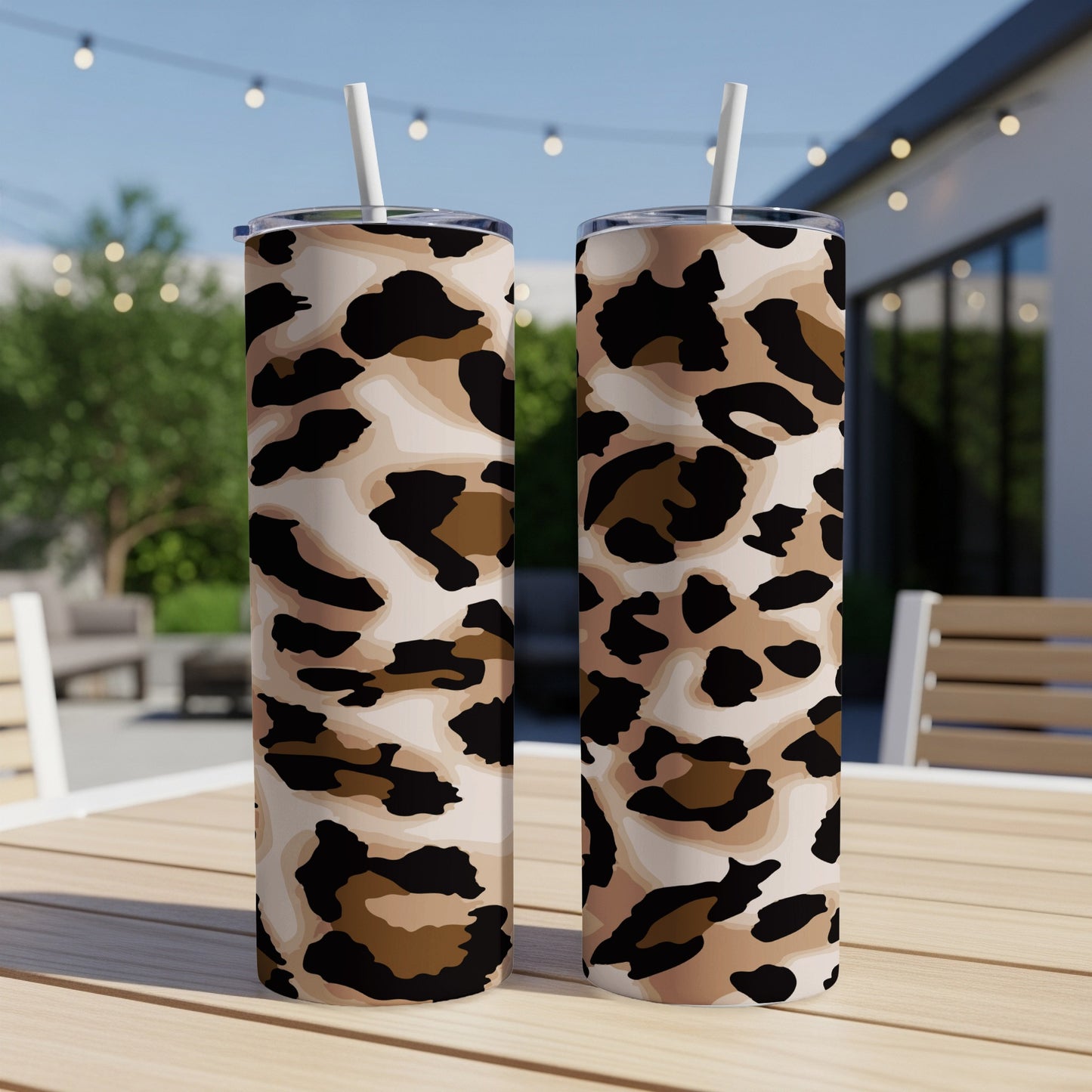 Two tall tumblers with a light leopard print design, each with a white straw.