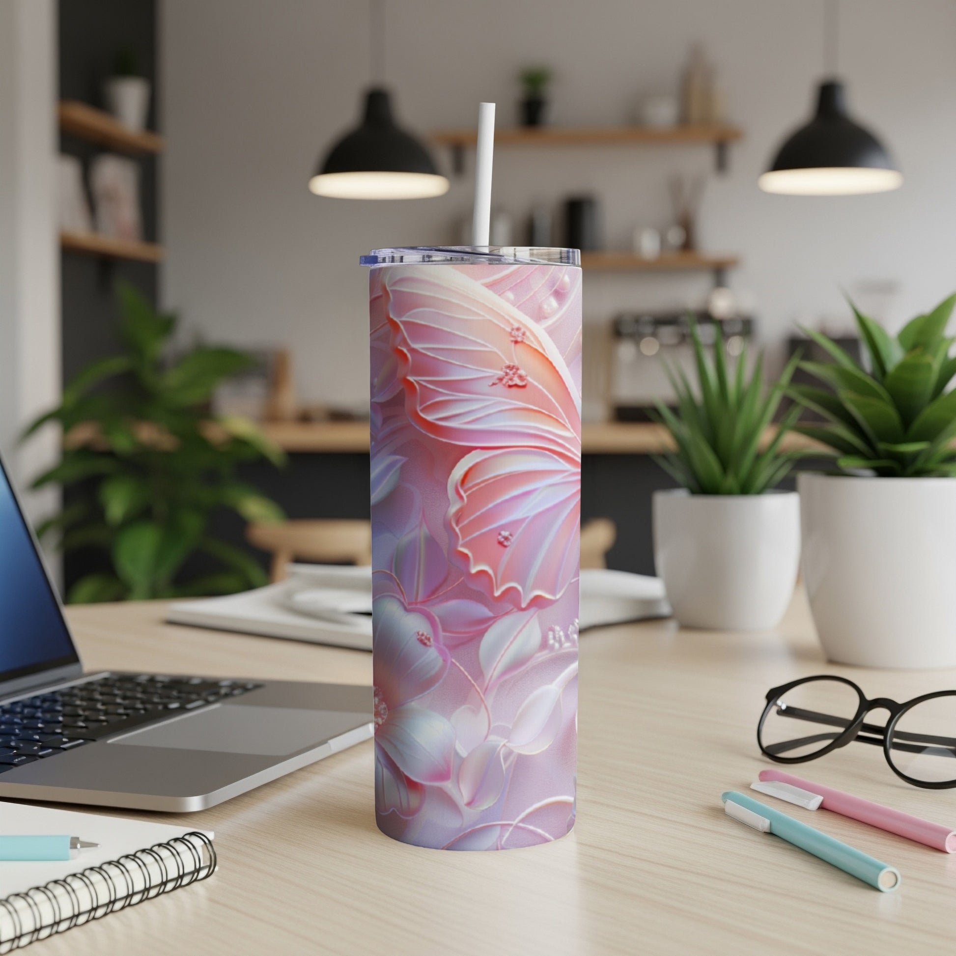 Pink butterfly floral skinny tumbler with white straw on desk.